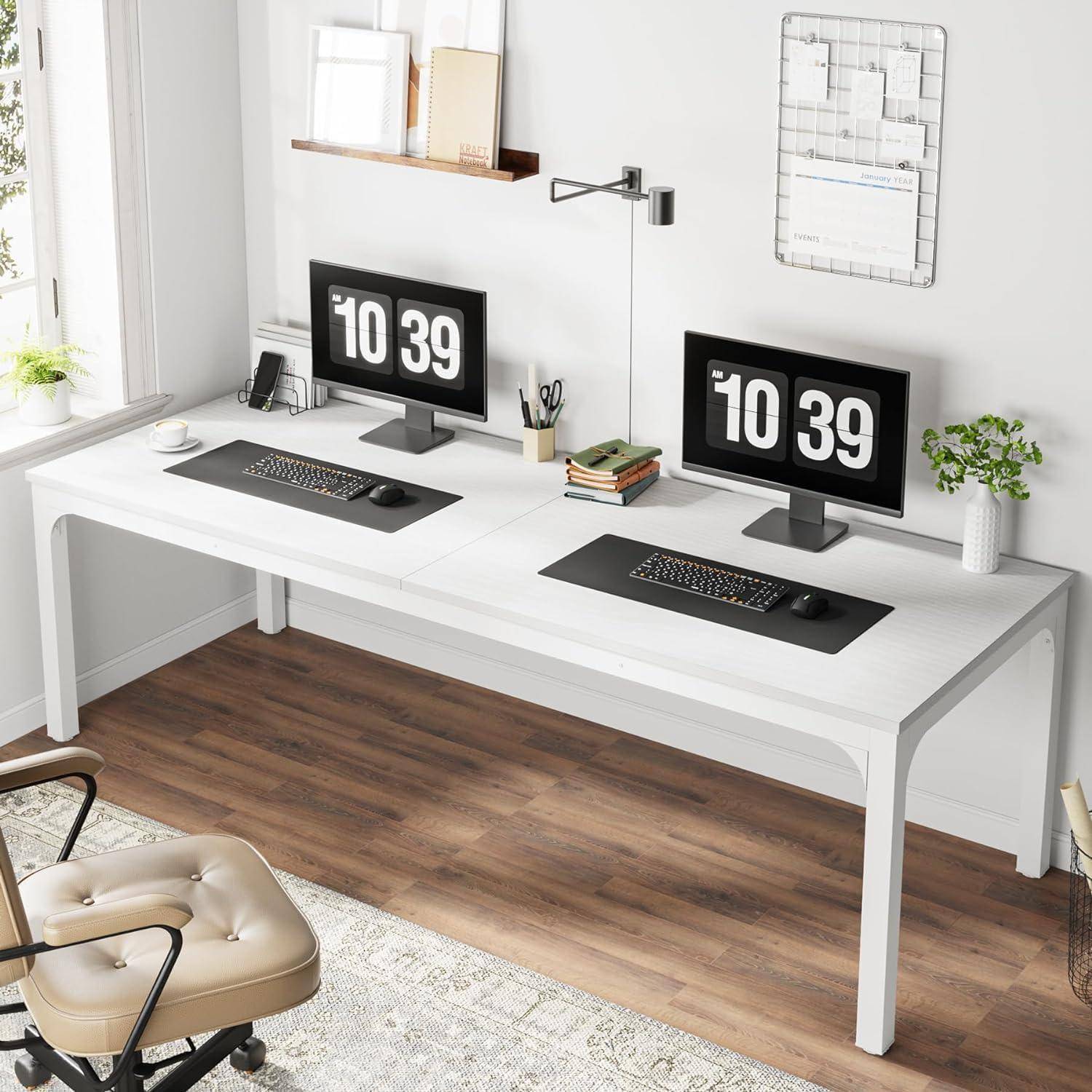 Modernes minimalistisches Homeoffice mit zwei Monitoren, die „10:39" anzeigen, dualen Tastaturen und Mäusen auf einem langen weißen Schreibtisch neben einem Fenster.