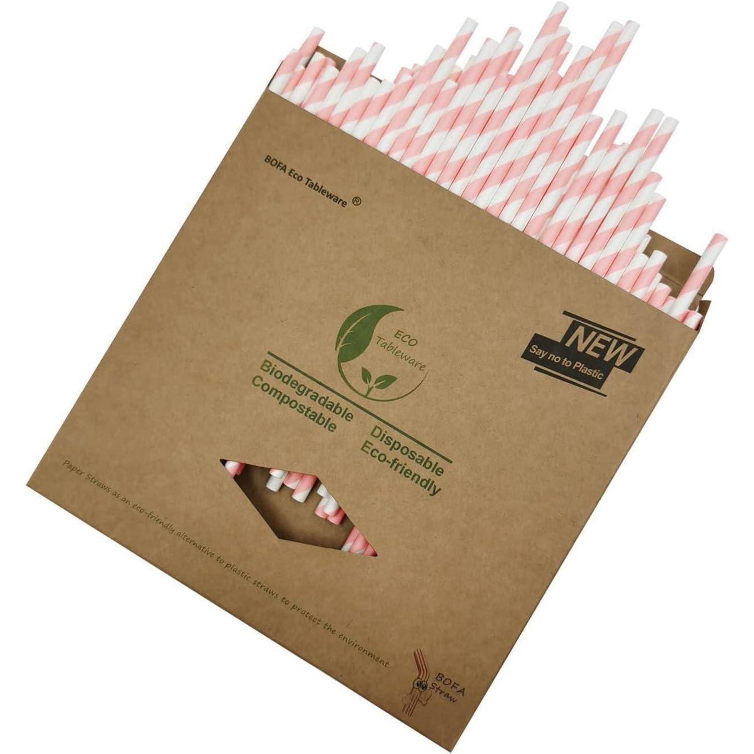 Braune Kartonbox mit rosa-weißen Papierstrohhalmen mit der Aufschrift Öko-Geschirr, biologisch abbaubar, kompostierbar, Einweg und „NEU Sag nein zu Kunststoff