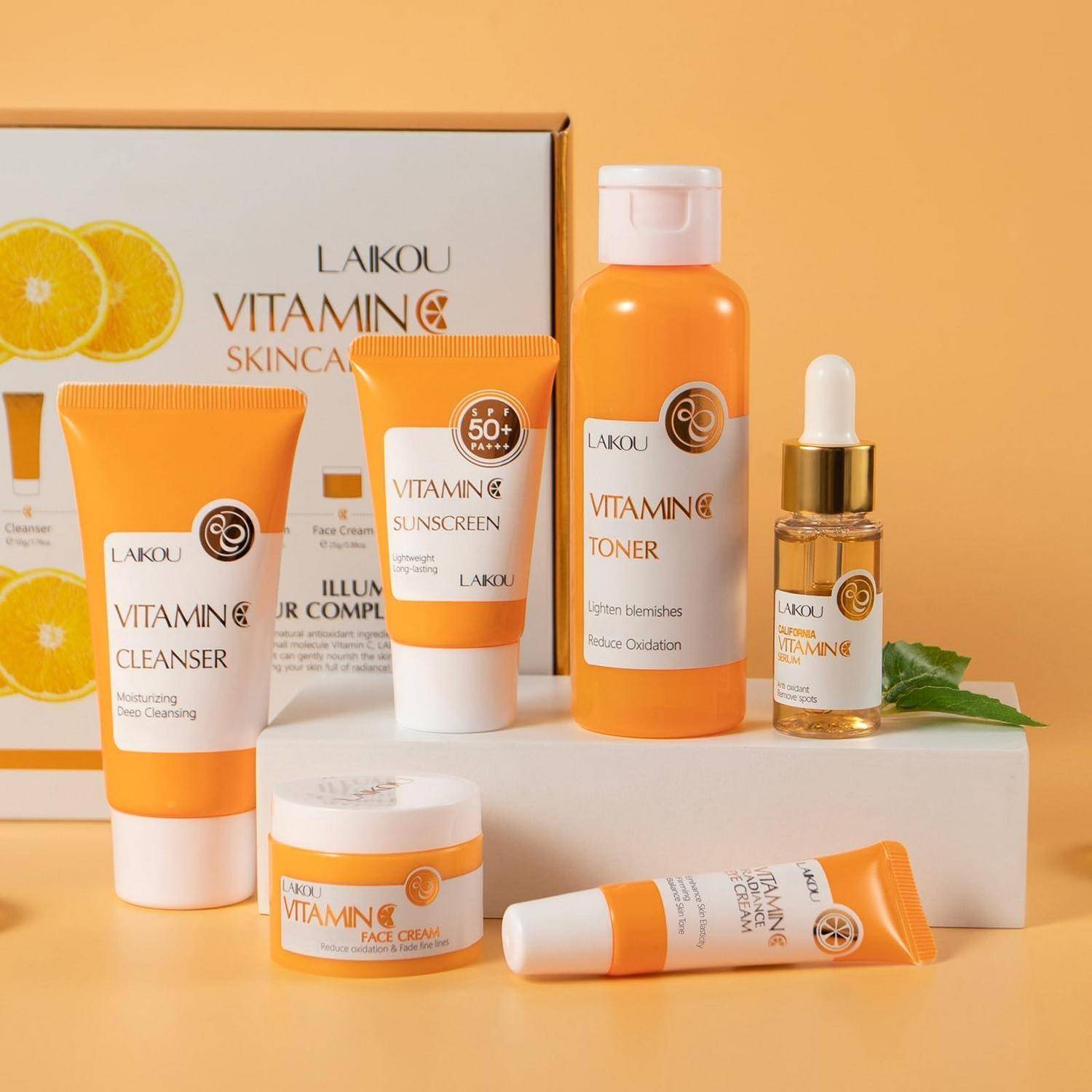 LAIKOU Vitamin C Hautpflegeset mit Reiniger, Sonnenschutz, Toner, Gesichtscreme und Serum, präsentiert in oranger Verpackung auf einer weißen Plattform.