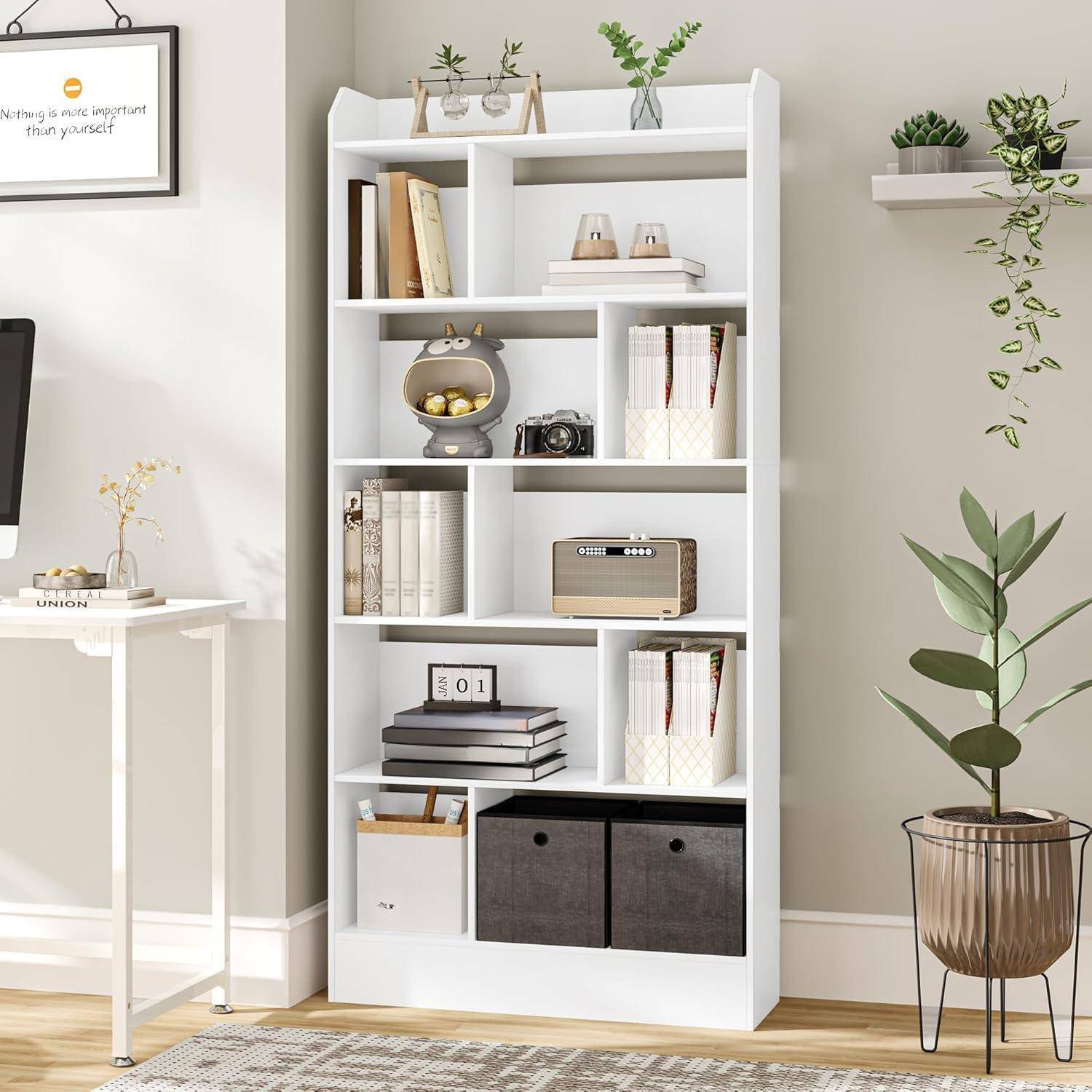 Weißes Bücherregal mit Büchern, Körben, Deko und einem kleinen Radio in einem hellen, minimalistischen Zimmer mit Topfpflanzen.