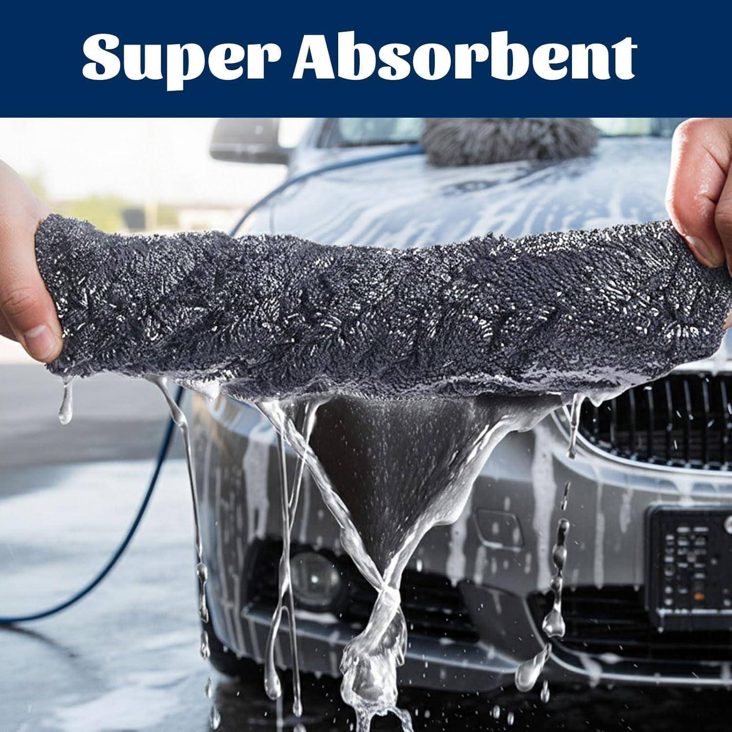 Autowäsche-Handtuch, das von Händen vor einem nassen Auto gedehnt wird, mit Wasser, das davon abfließt; die Überschrift lautet „Super saugfähig