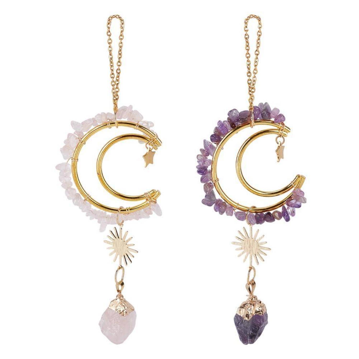 Paar Ohrringe in Halbmondform mit Goldketten, eines in Hellrosa und eines in Lila, jeweils mit Kristallakzenten und einem baumelnden Steinanhänger.