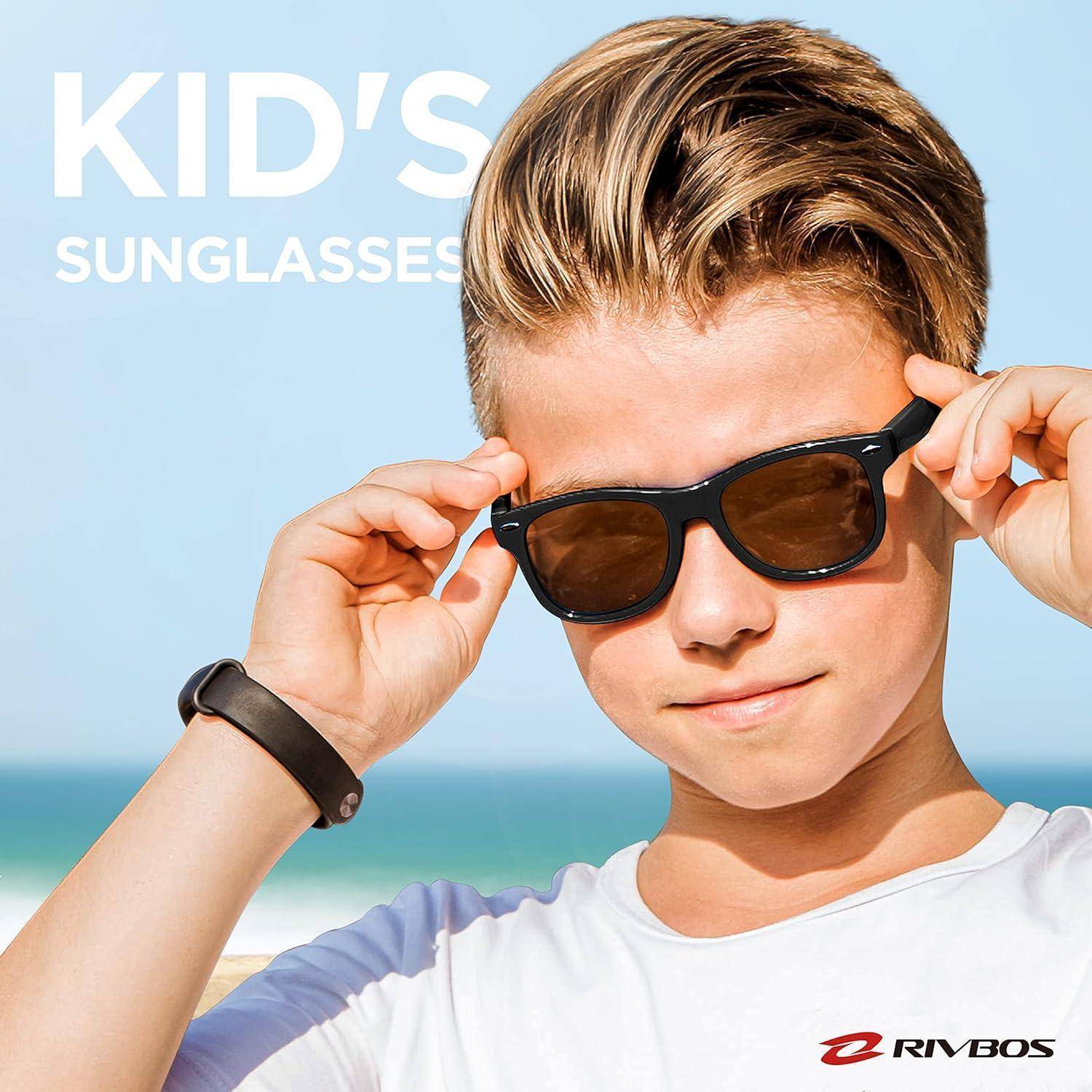Junge passt schwarze Sonnenbrillen am Strand an, mit dem Text „KINDERSONNENBRILLEN" und dem Logo „RIVBOS"".