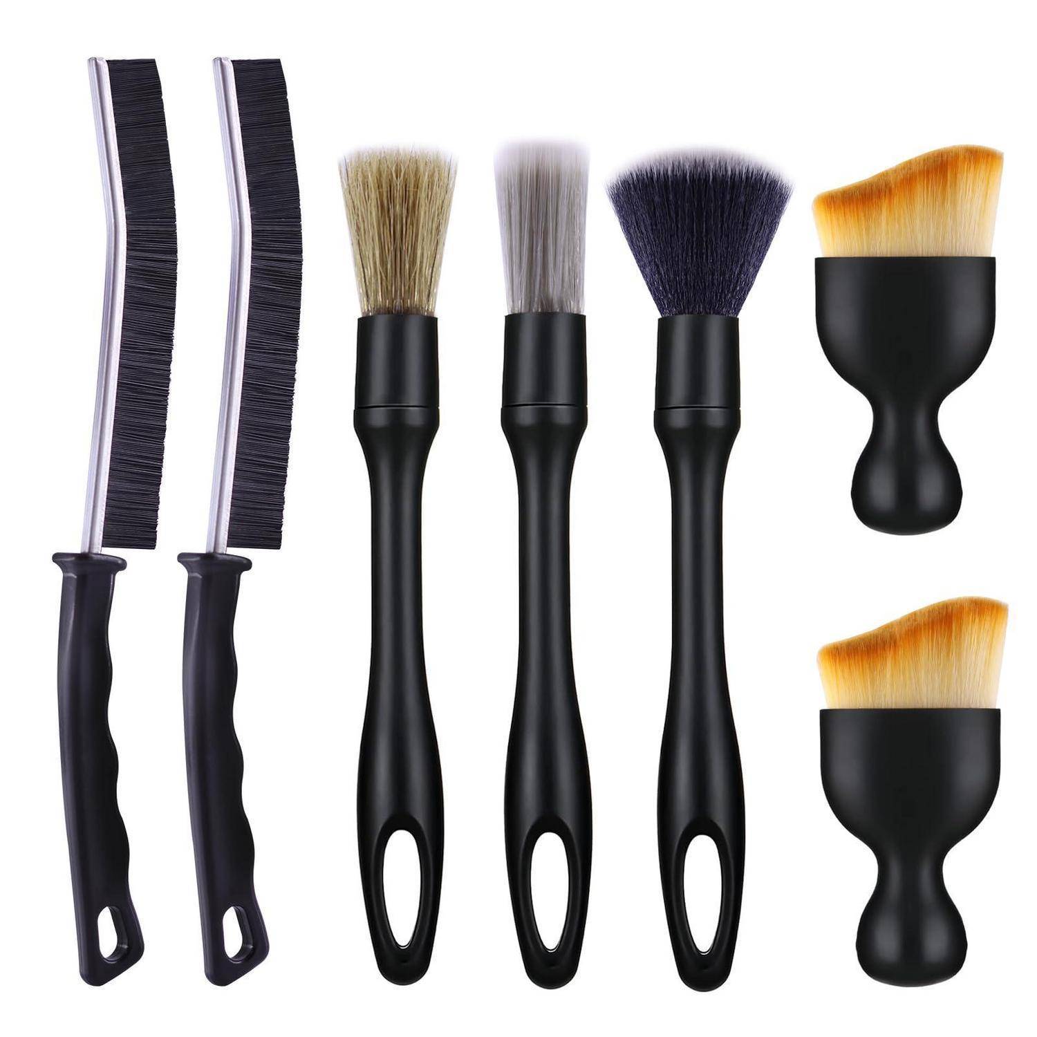 Satz aus sechs Haarstyling-Werkzeugen und Bürsten: zwei lange schwarze Kämme, drei schwarzgriffige Naturhaarbürsten und zwei kleine runde Applikatorbürsten mit orangefarbenen Borsten.