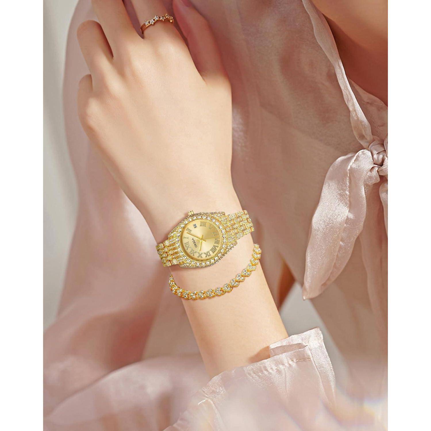 Nahaufnahme des Handgelenks einer Frau mit einer goldenen Uhr und einem passenden Armband vor einem weichen rosa Satin-Bluse.