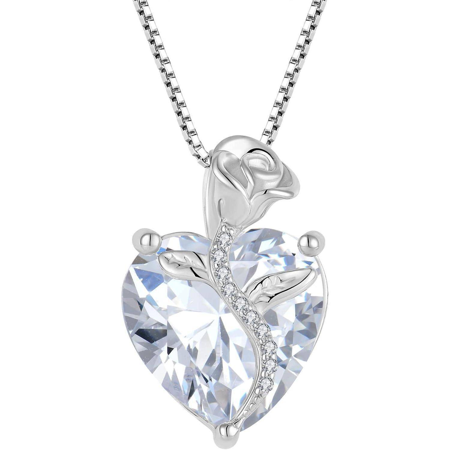 Silberner herzförmiger Anhängerkettenschmuck mit einem klaren facettierten Kristallherz und einem Rosendesign, akzentuiert durch kleine Steine an einer Kette, isoliert auf Weiß.