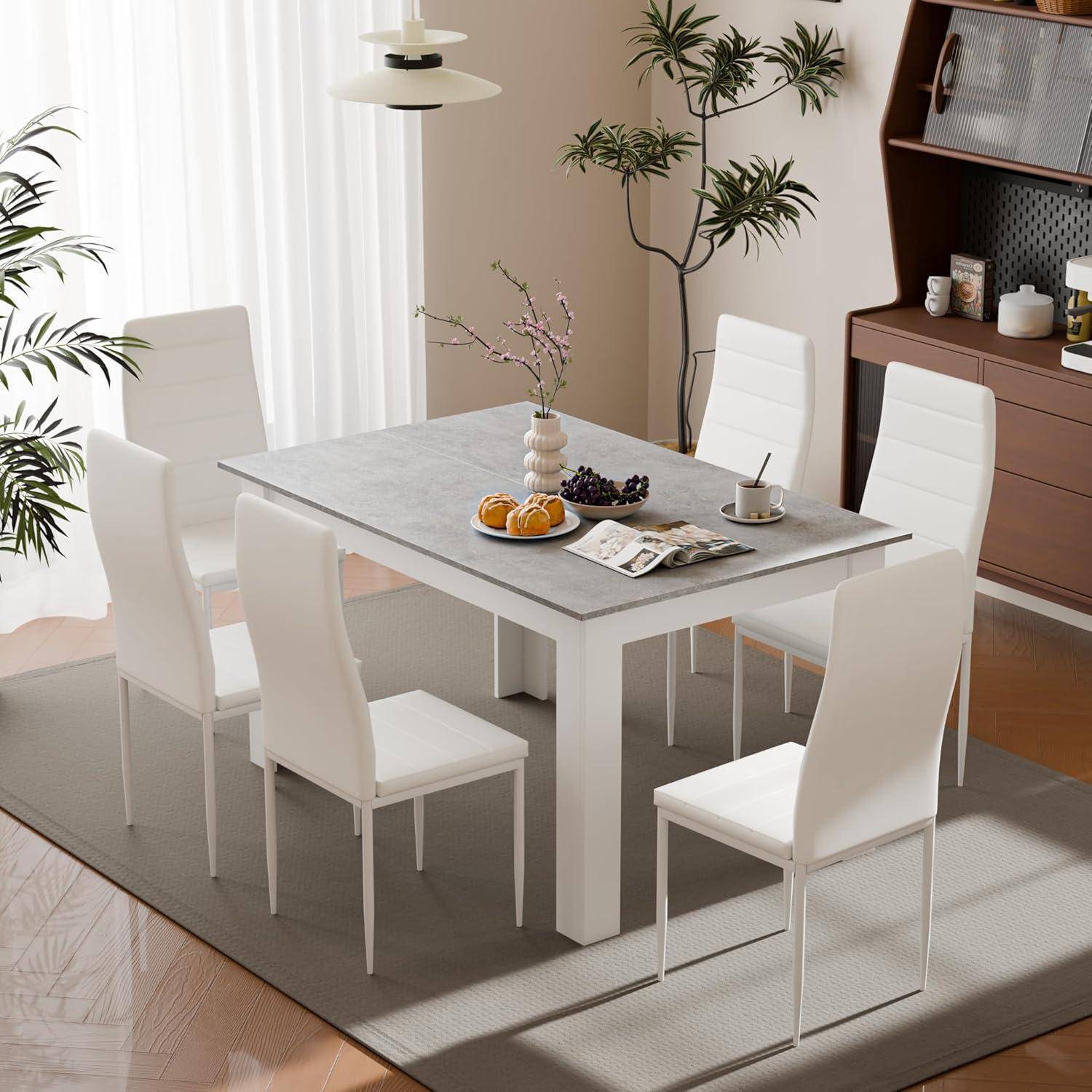 Modernes Esszimmer mit einem weißen Tisch, vier weißen Stühlen und einer kleinen Frühstücksecke neben einem Fenster und einem Schrank.