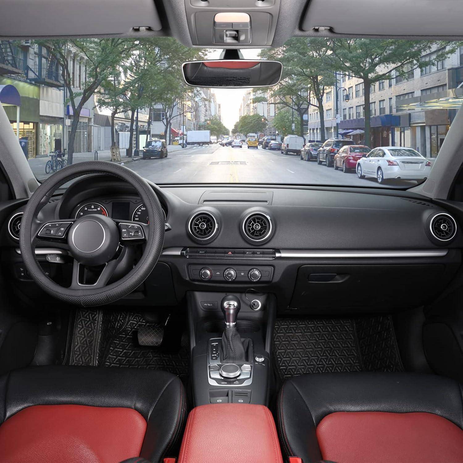 Blick vom Rücksitz eines geparkten Autos, der das Armaturenbrett, das Lenkrad und eine Stadtstraße durch die Windschutzscheibe zeigt.