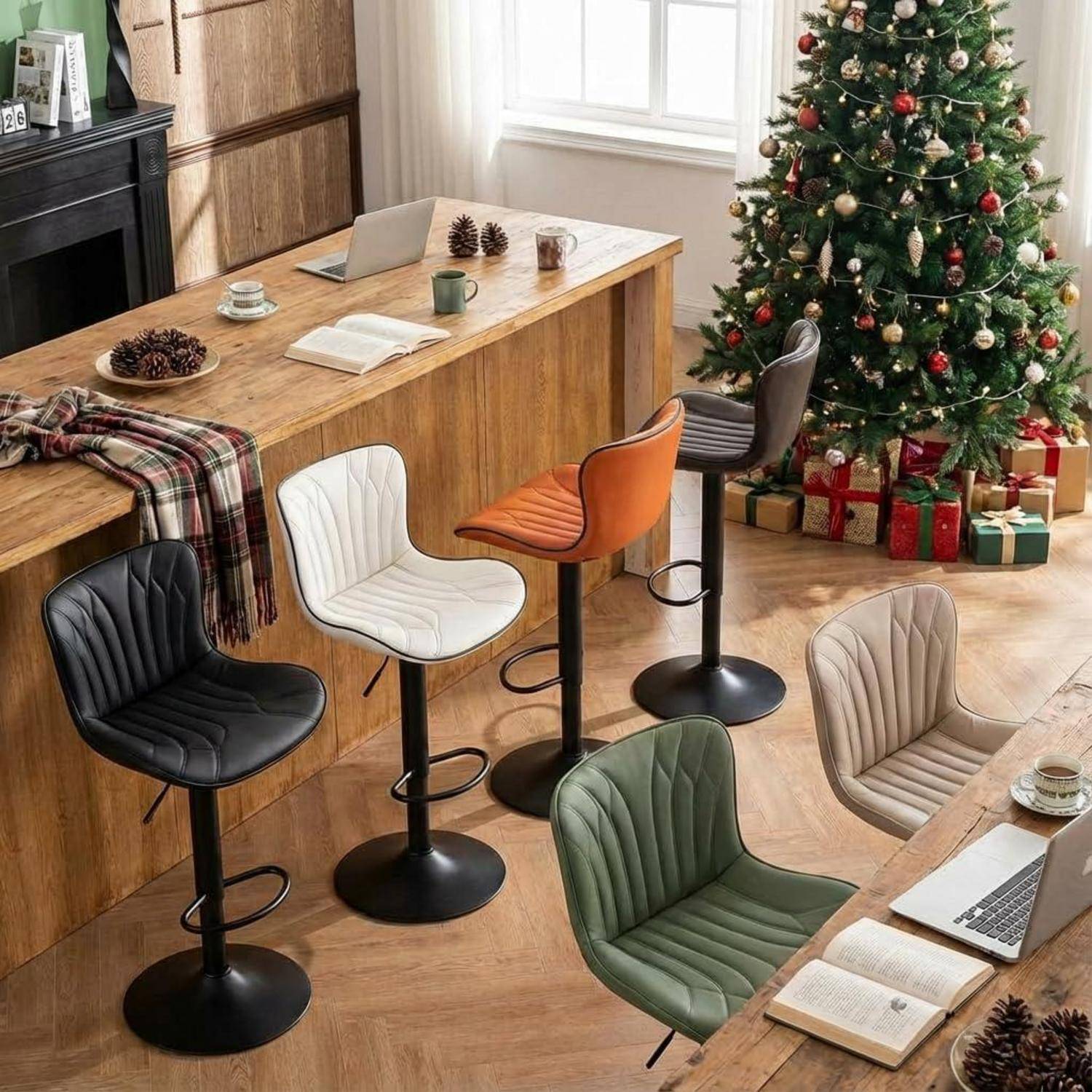Stilvolles Heimarbeitszimmer mit mehreren bunten Barhockern um einen Holztresen, offene Bücher und Laptops, neben einem geschmückten Weihnachtsbaum mit Geschenken.