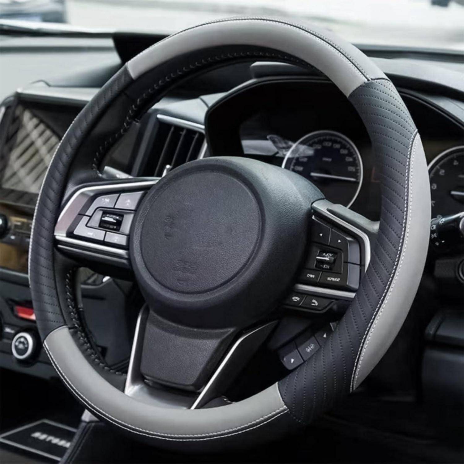 Nahaufnahme eines Lenkrads eines Autos mit integrierten Steuertasten und einer digitalen Instrumententafel dahinter.