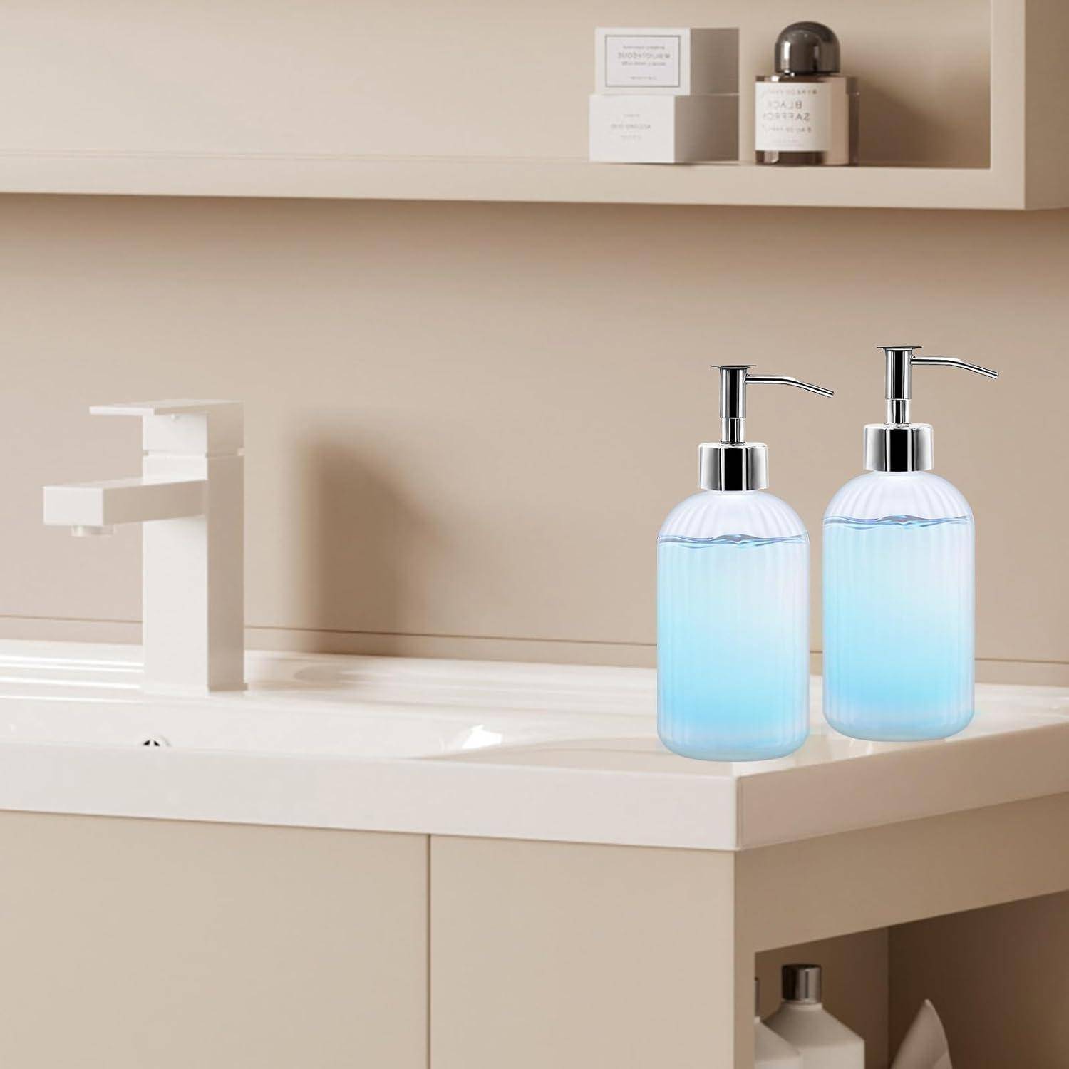 Minimalistische Badezimmerkommode mit weißem Waschbecken, Wasserhahn und zwei blauen Seifenspendern auf der Arbeitsplatte, mit passendem Regal darüber.