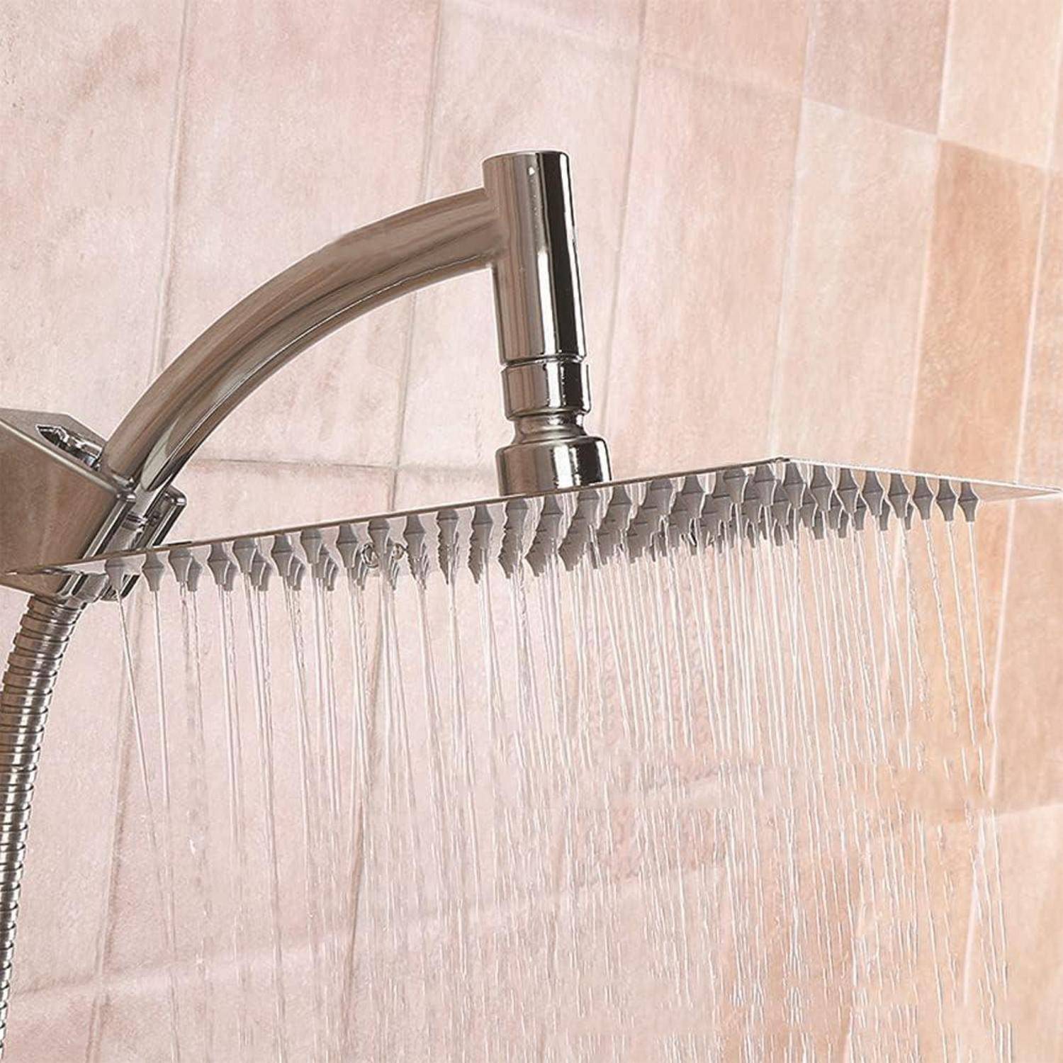 Nahaufnahme eines modernen verchromten Regenduschkopfs, der Wasser gegen eine geflieste Badezimmerwand sprüht.