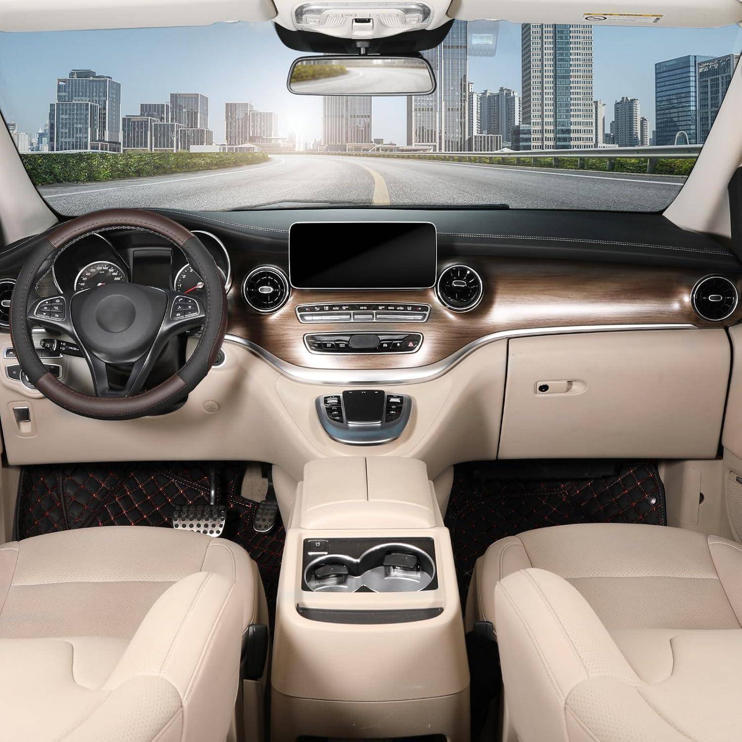 Leere Luxusauto-Innenausstattung mit beigen Sitzen, Holzverkleidung am Armaturenbrett, zentrales Display, Lenkrad und Blick auf die Straße der Stadt durch die Windschutzscheibe.