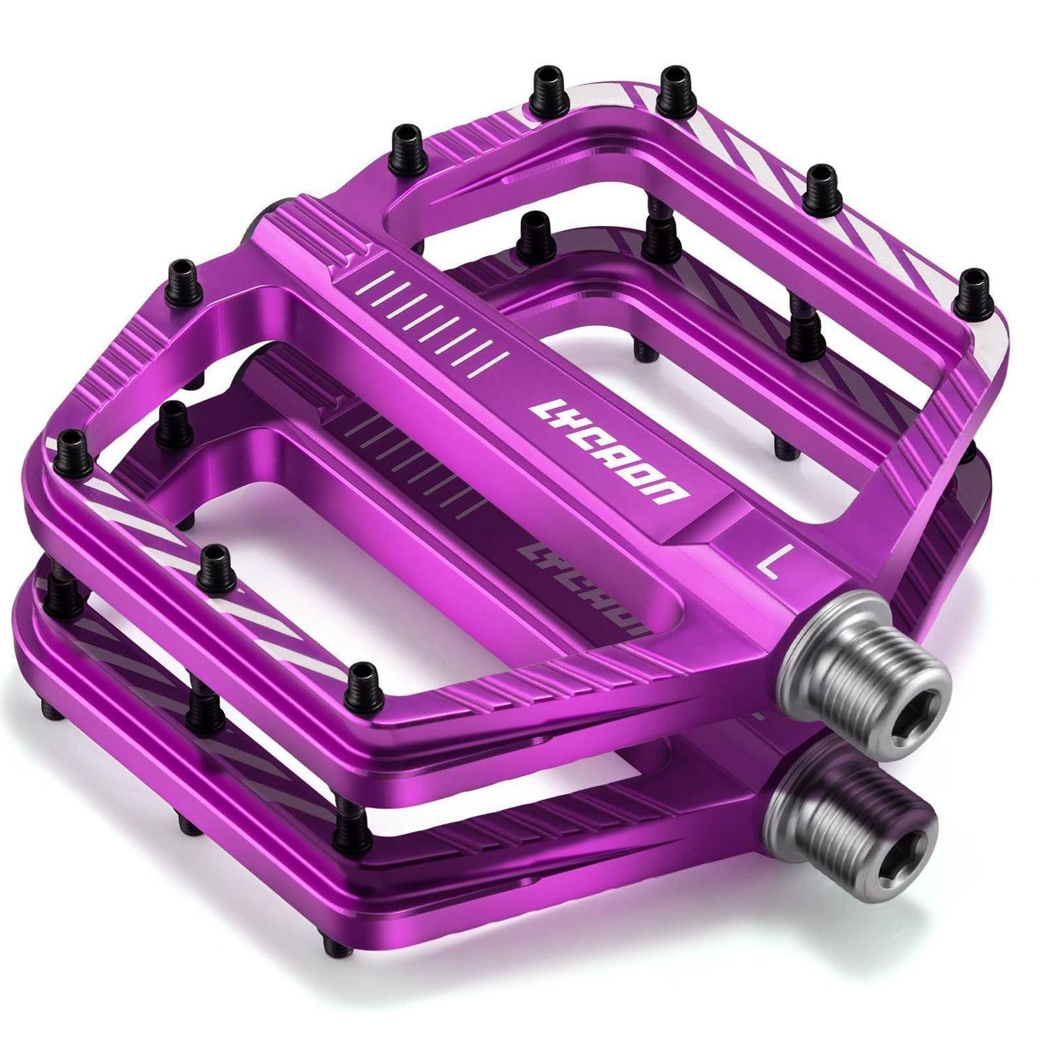 Violette Fahrradpedale mit Metallgewinde, von einem schrägen Blickwinkel auf weißem Hintergrund dargestellt.