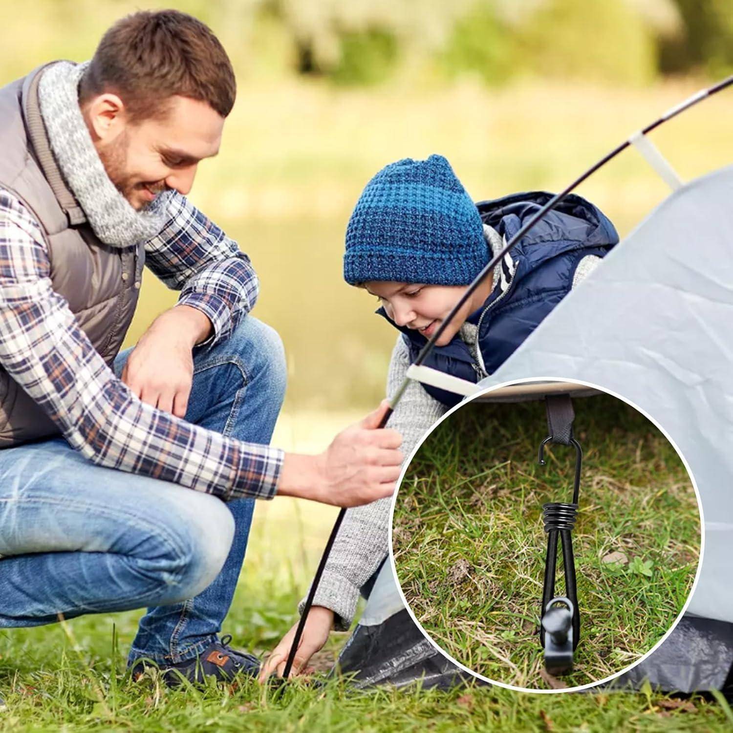 Mann und Kind bauen ein kleines Zelt im Freien auf, mit einer Nahaufnahme eines in das Gras getriebenen Zeltherrings.