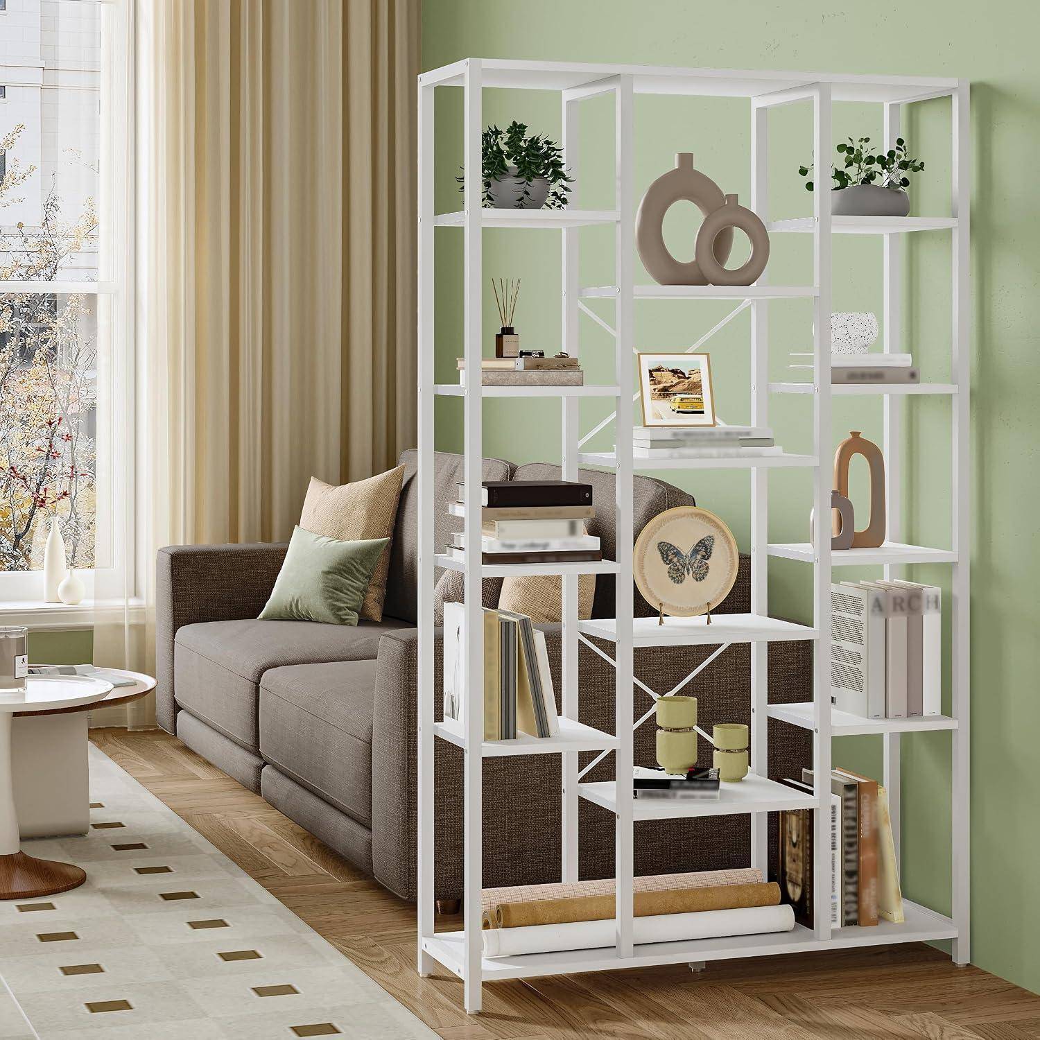 Modernes Wohnzimmer mit einer weißen geometrischen Regalnische, die Dekoration, Bücher und einen Laptop neben einem grauen Sofa und einem Fenster ausstellt.