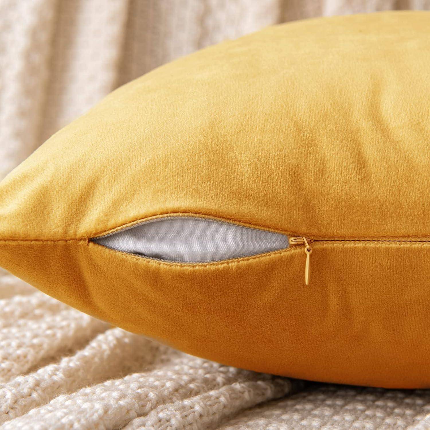 Nahaufnahme eines senfgelben Kissens mit einer teilweise geöffneten Naht, die die weiße innere Füllung auf einer strukturierten beigefarbenen Decke zeigt.