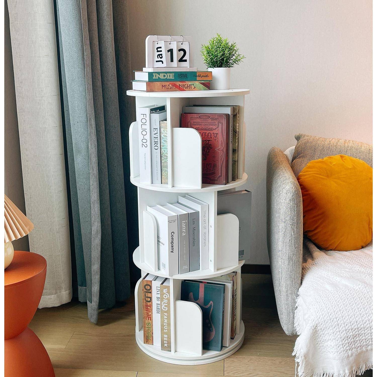 Weißes rotierendes Bücherregal mit Büchern, ein Schreibtischkalender mit dem Datum 12. Januar, und eine kleine Pflanze neben einem beigen Sessel mit einem orangefarbigen Kissen.