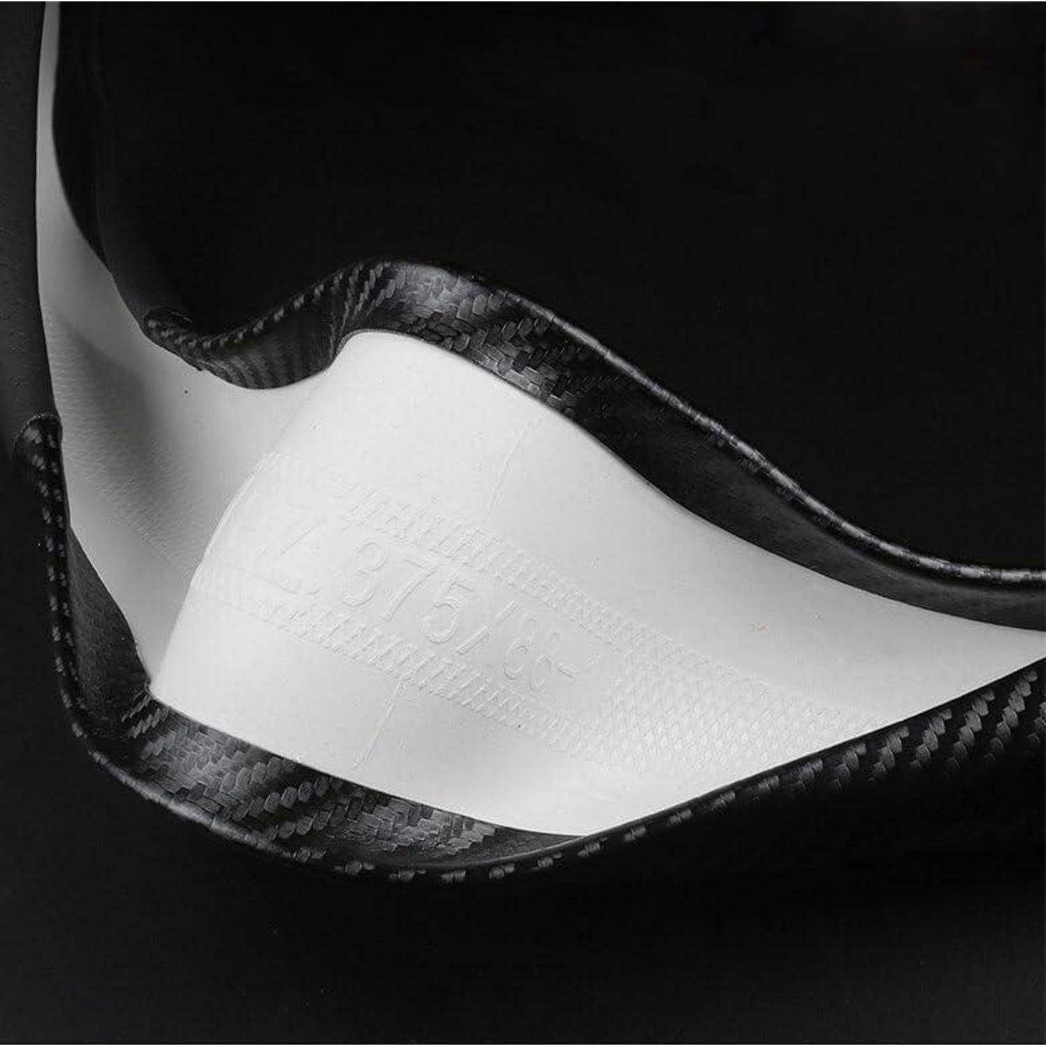 Nahaufnahme einer schwarzen Kohlefaser-Tasche oder eines Kohlefaser-Koffers mit einer weißen Innenklappe vor dunklem Hintergrund.