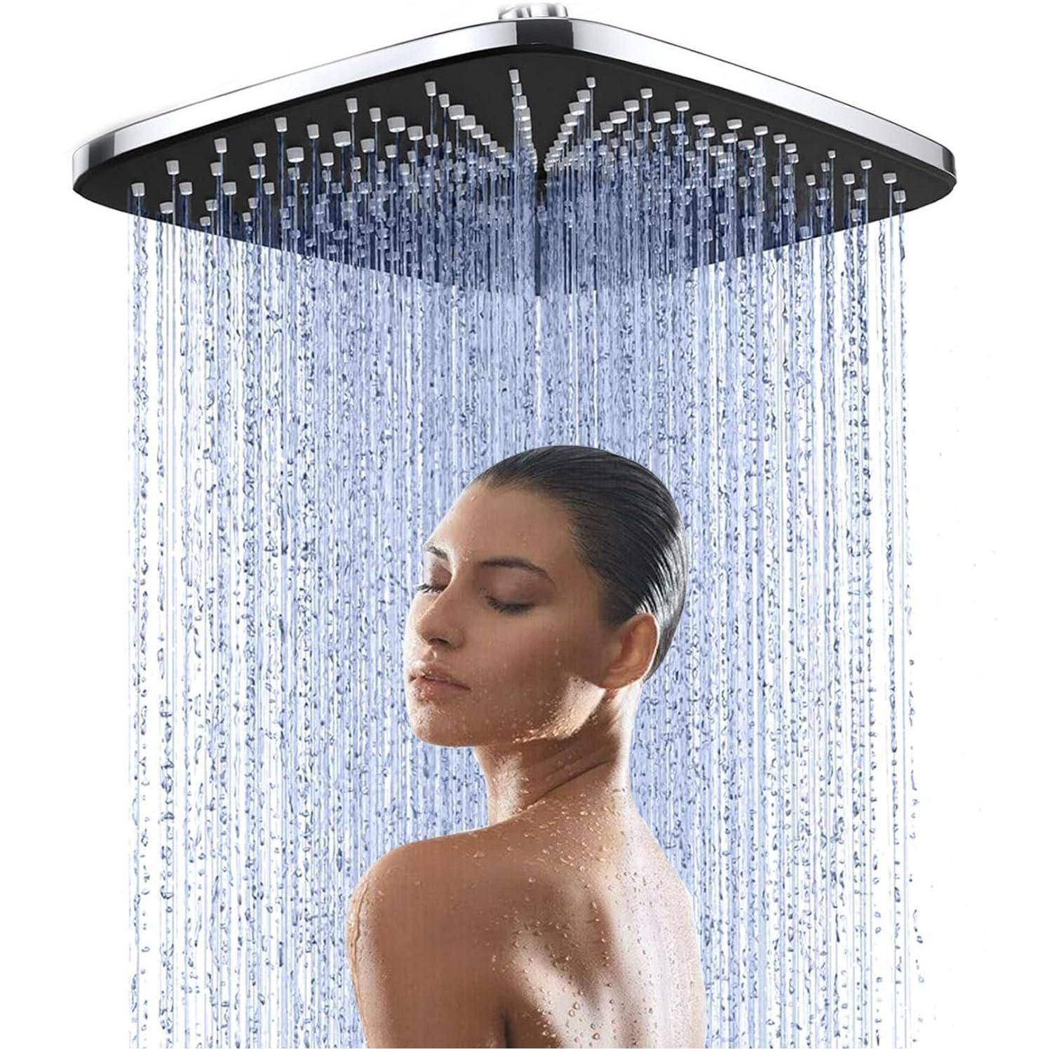 Frau, die unter einem großen quadratischen Regenfallduschkopf steht, die Augen geschlossen, mit Wasser, das über ihre Schultern strömt, vor weißem Hintergrund.