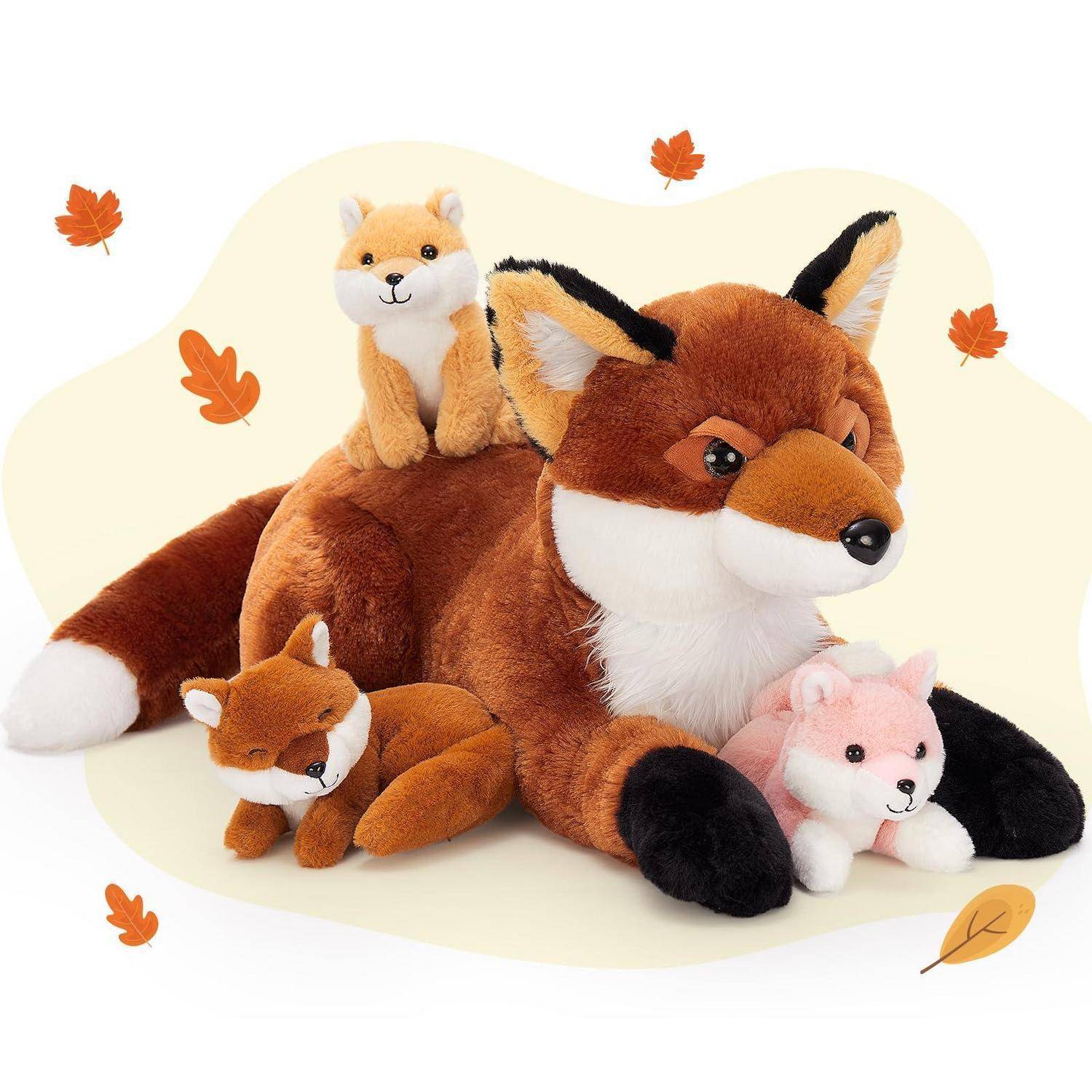 Weiches Fuchs-Familien-Spielzeug-Set: großer Fuchs mit drei kleineren Fuchs-Plüschtieren, arrangiert auf hellem Hintergrund mit fallenden Herbstblättern.