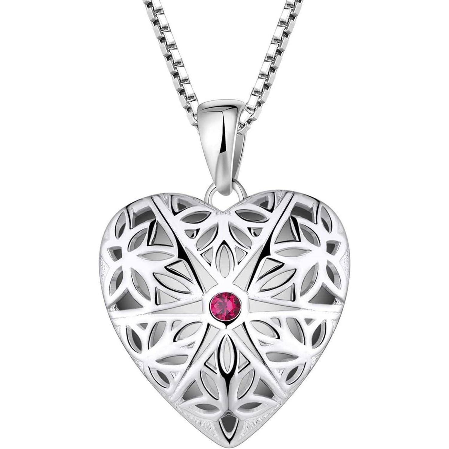 Silberne herzförmige Anhängerkette mit Filigran-Aussparungsdesign und einem kleinen rosa Edelstein in der Mitte.