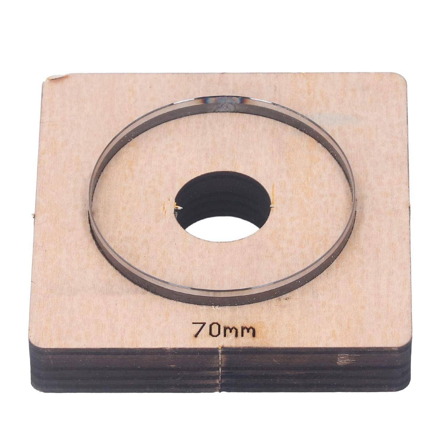 Holzlehre mit Kennzeichnung '70mm' mit kreisförmiger Aussparung und erhöhtem Metallring, wahrscheinlich zum Messen oder Kalibrieren von Rundteilen verwendet.