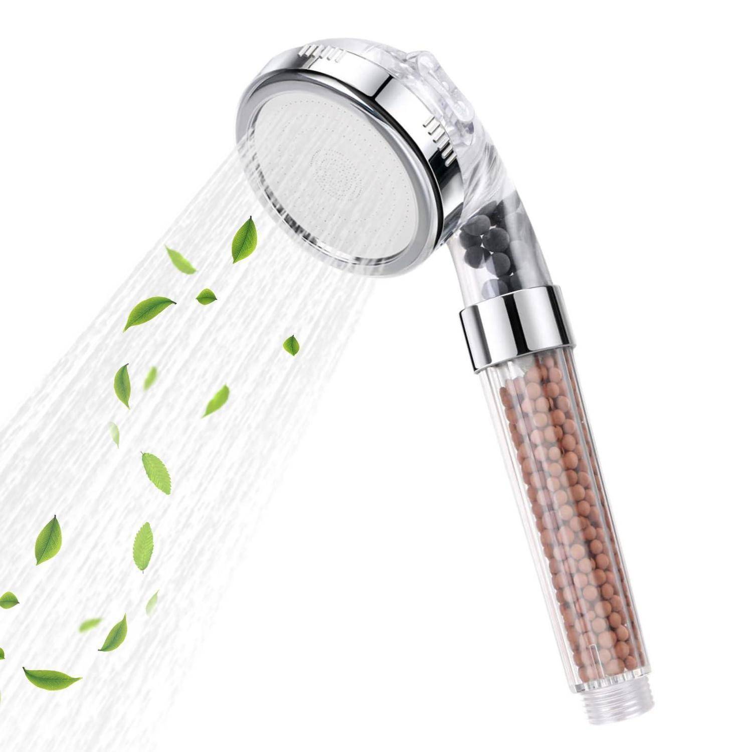 Tragbarer Duschkopf mit sichtbaren Filterkartuschen, der Wasser und grüne Blätter sprüht und auf ein Filtrations- oder umweltfreundliches Wassersparprodukt hindeutet.