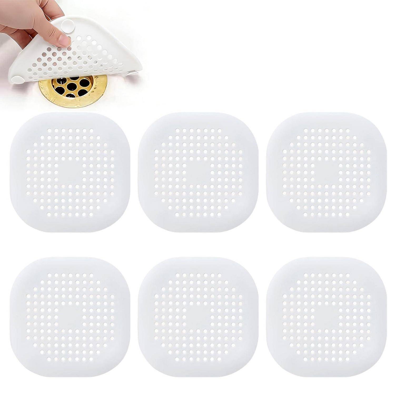 Weiße Klebstoff-Ablaufabdeckungen mit perforierten Löchern, gezeigt als 6er-Pack mit einer Abdeckung, die über einem Spülenablauf abgezogen wird.