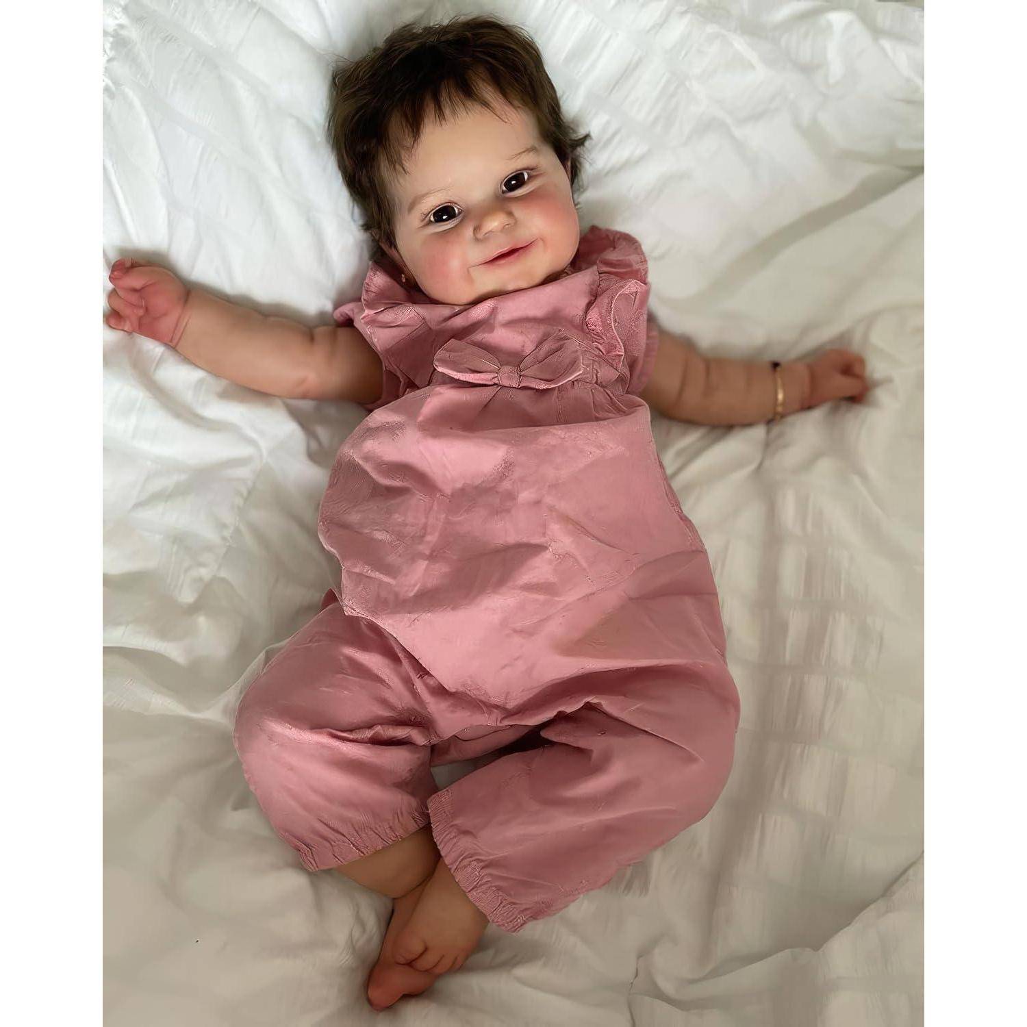 Lächelndes Baby, das auf einem weißen Bett liegt, einen rosa Anzug trägt und in die Kamera schaut.