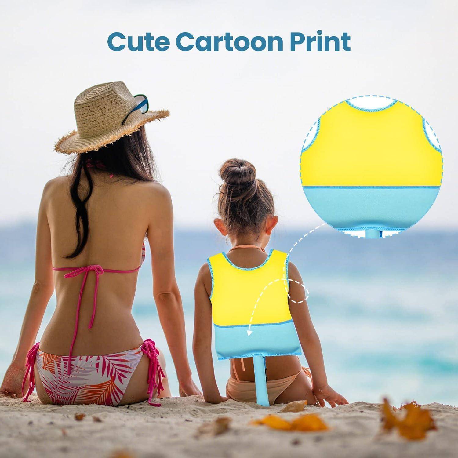 Mutter und Kind sitzen am Strand und tragen passende gelb-blaue Rettungswesten mit einem „niedlichen Cartoon-Druck