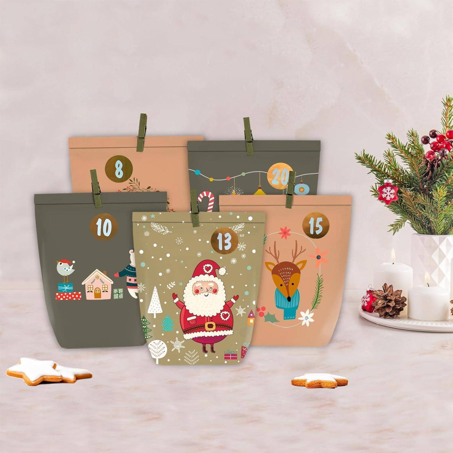 Fünf Adventskalender-Säckchen im Weihnachtsdesign mit nummerierten Taschen, verziert mit Weihnachtsmann, Rentieren und Wintermotiven auf einer Tischplatte neben einer Kerze und grünem Schmuck.