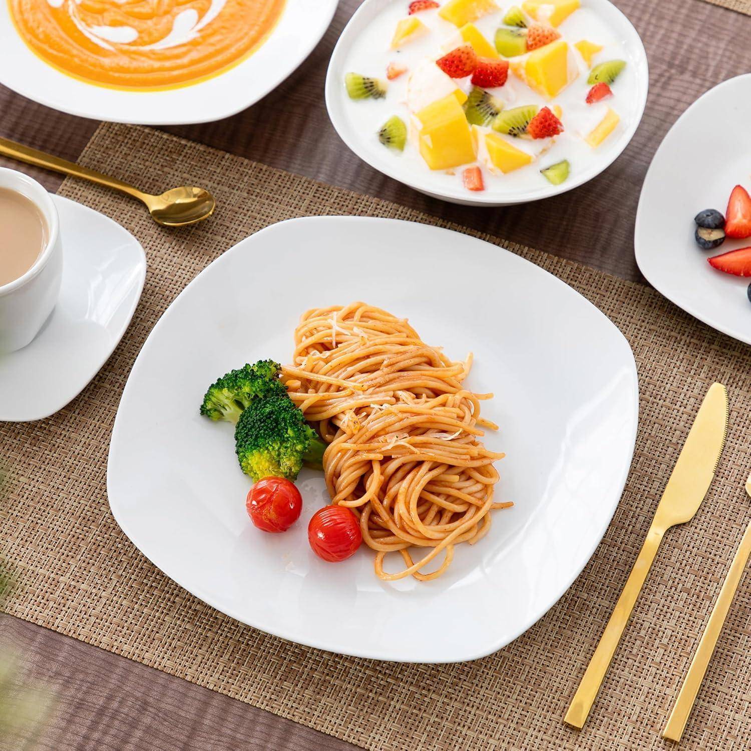 Teller mit Spaghetti, Brokkoli und Kirschtomaten auf einem Tisch, umgeben von anderen Gerichten mit Suppe und Obstdessert.