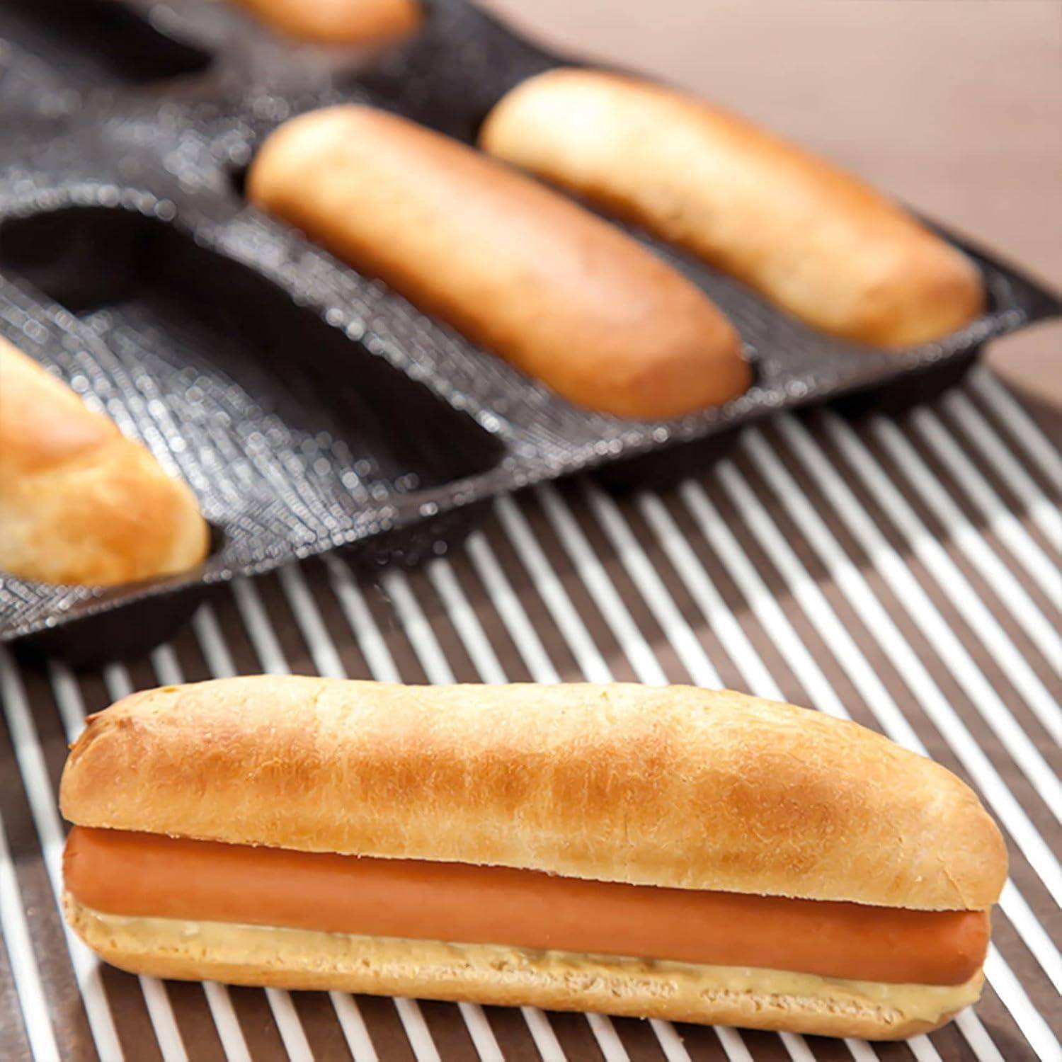 Frisch gebackene Brötchen mit einer Wurst in einer Pfanne, aus nächster Nähe auf einem Abkühlgitter betrachtet.