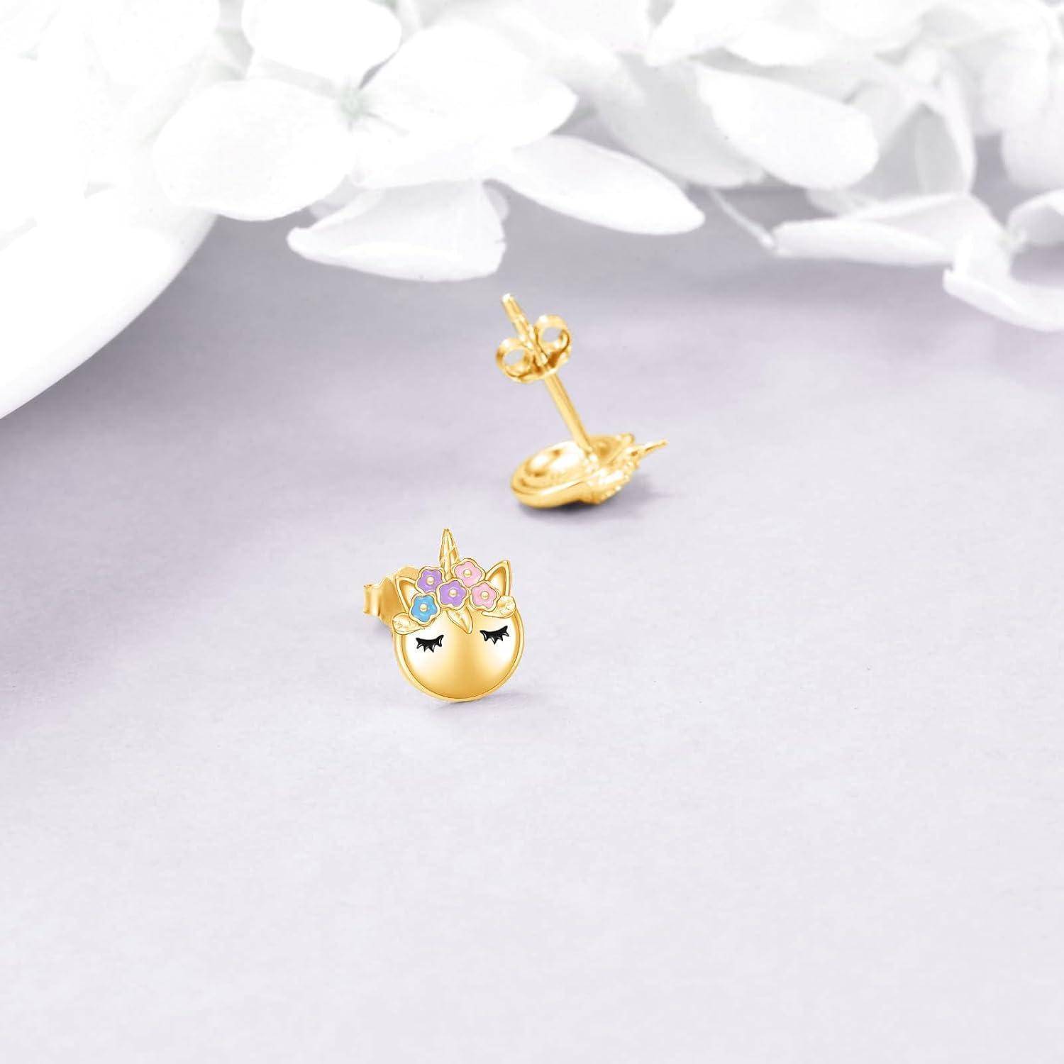 Goldene Einhorn-Stecker mit pastellfarbenen Blumen- und Edelsteinakzenten, auf weichem weißem Hintergrund gezeigt