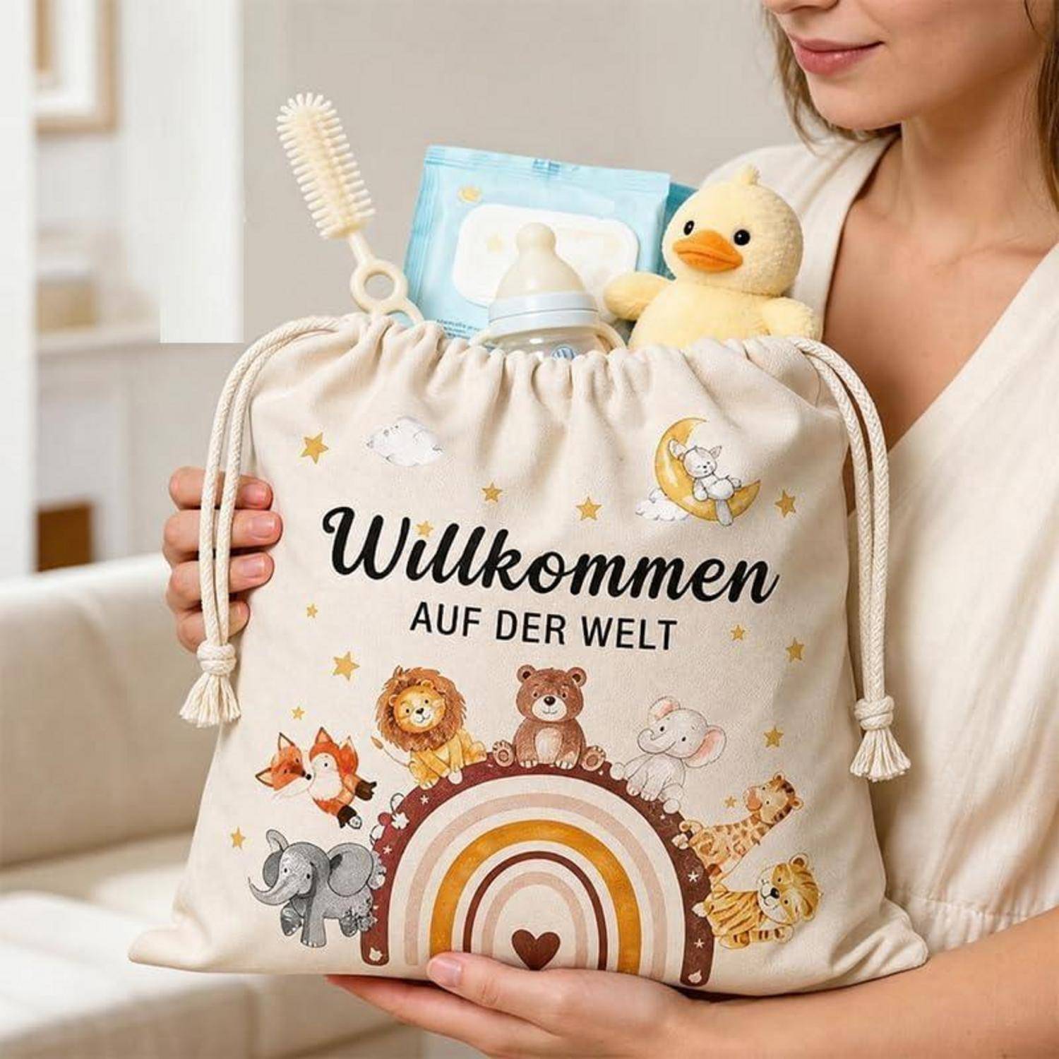 Frau, die eine beigefarbene Baby-Geschenktasche hält, die mit „Willkommen auf der Welt" bedruckt ist, und Tieren um einen Regenbogen herum, gefüllt mit Babyprodukten.