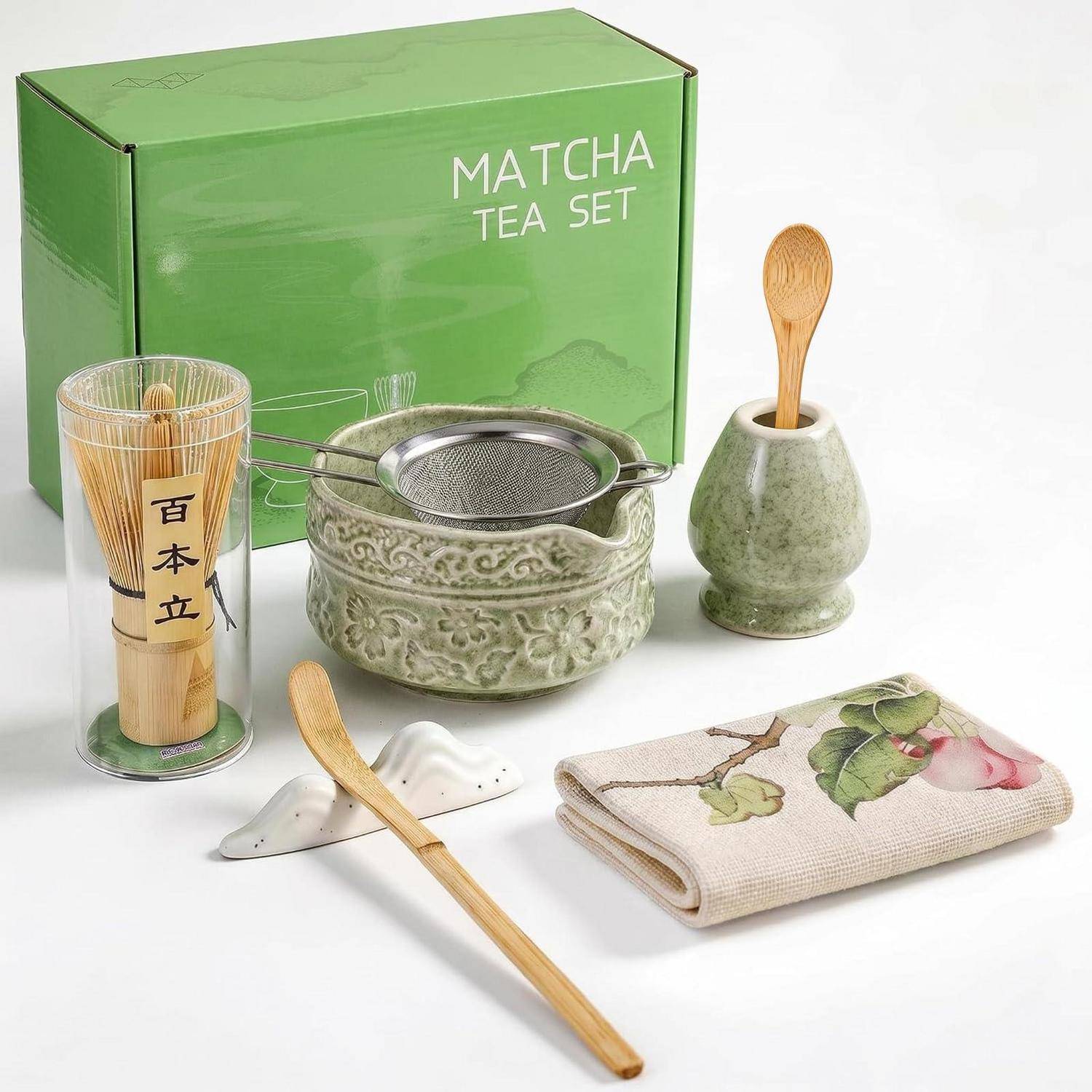 Matcha-Tee-Set mit grüner Schachtel, Bambusquirl, Keramikschale und Löffel, Sieb, Löffelhalter, Bambusschaufel und Blumentuch auf weißem Hintergrund.