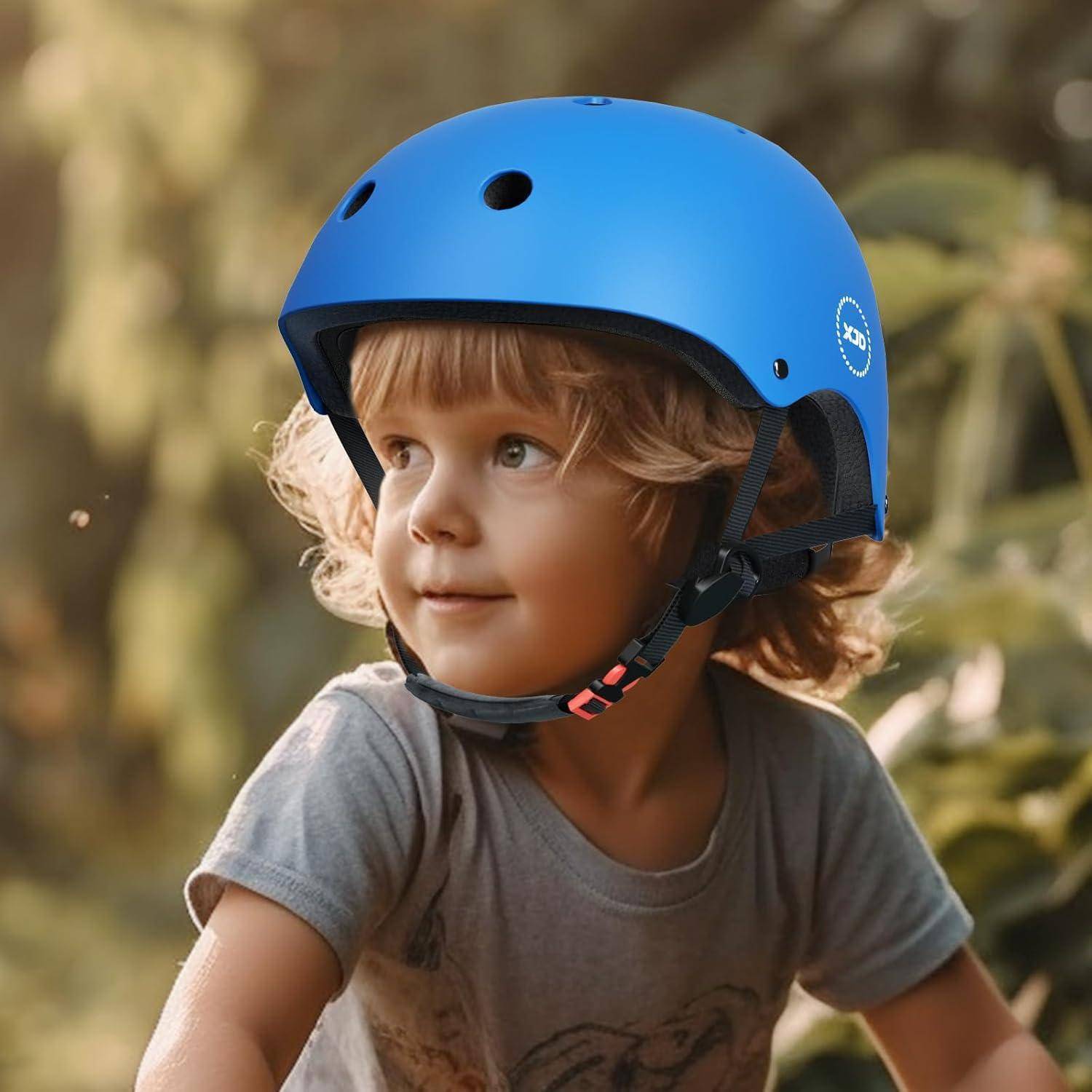 Kleines Kind mit einem leuchtend blauen Helm, das nach der Seite schaut, draußen im weichen Sonnenlicht.