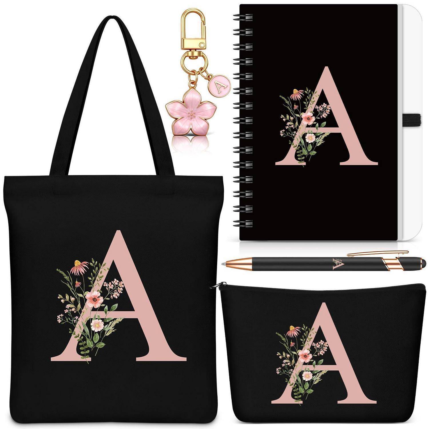 Florales Monogramm-'A'-Tragetascheset mit Notizbuch, Schlüsselanhänger, Stift und Tasche auf schwarzem Hintergrund.