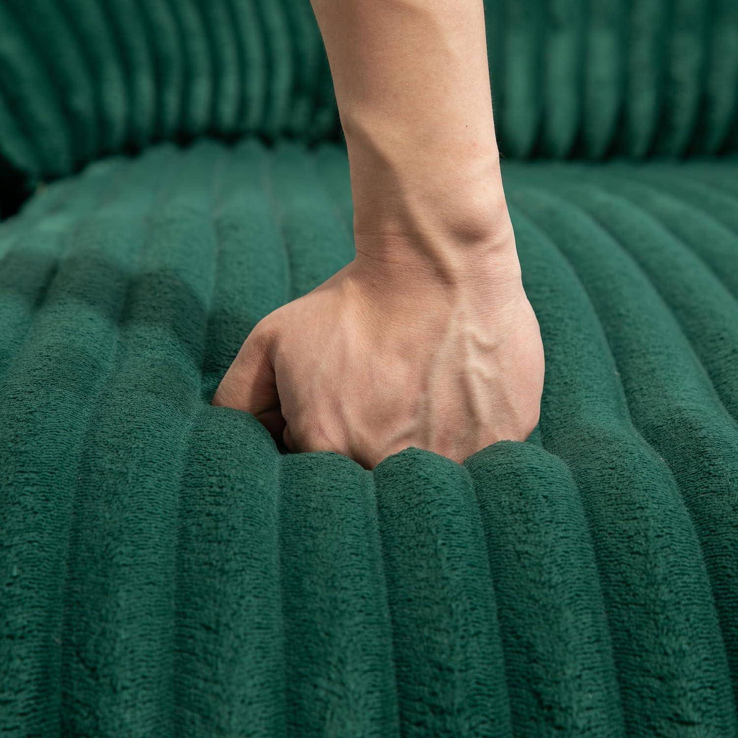 Hand drückt in eine grüne gepolsterte Oberfläche, die tiefe Weichheit und Textur zeigt.