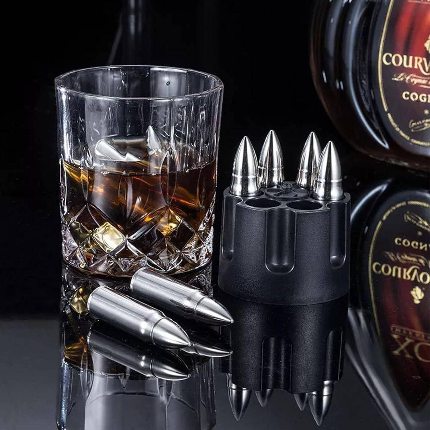 Whiskyglas mit Eis neben einem kugelförmigen Stifthalter und metallischen Stiften, mit einer Courvoisier-Flasche im Hintergrund.