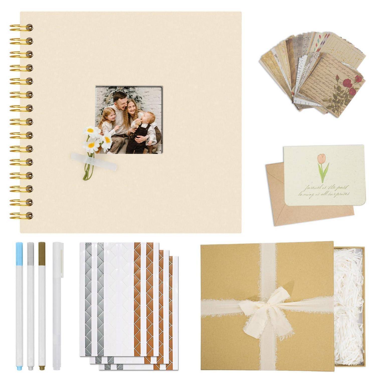 Scrapbook-Set mit einem spiralgebundenem Album, dekorativen Fotokarten, gemusterten Papierbogen, Stiften und einer geschenkverpackten Schachtel mit Materialien.