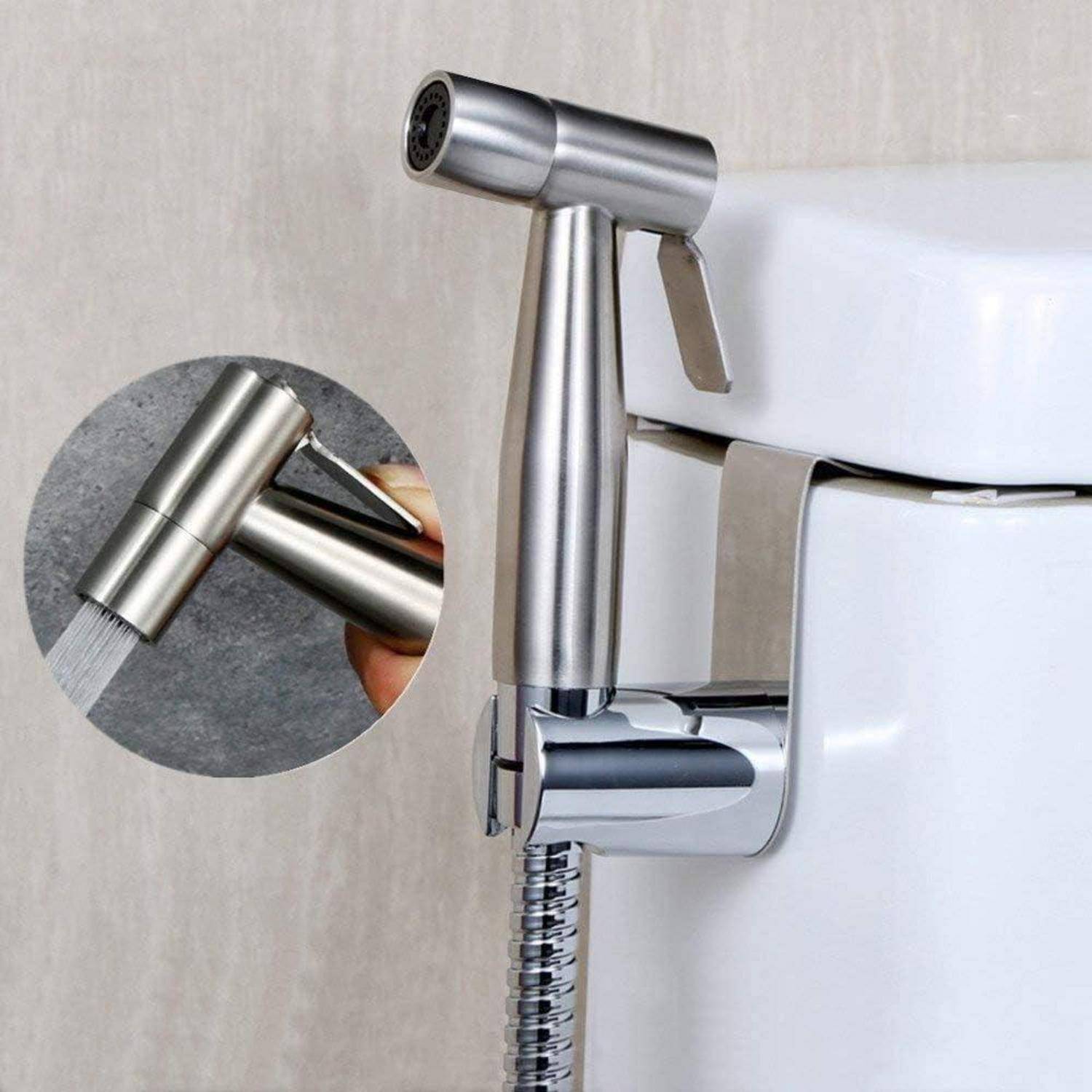 Tragbarer Bidet-Sprayer neben einer Toilette montiert, mit Detailaufnahme, die die Düse zeigt, aus der Wasser spritzt.