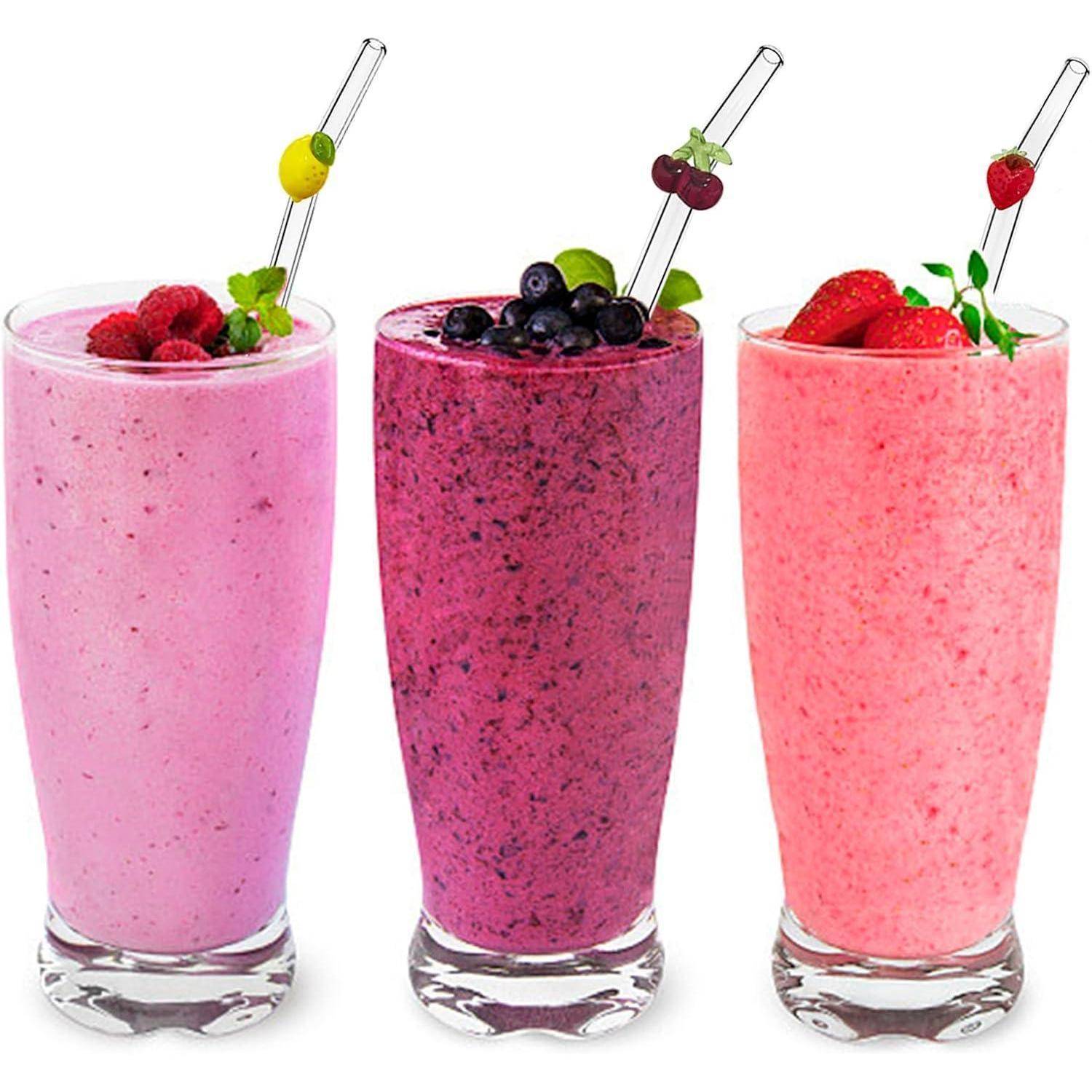 Drei Fruchtsmooties in hohen Gläsern – rosa Himbeere, lila Blaubeere und Erdbeere – jedes mit Obst und einem Strohhalm garniert.