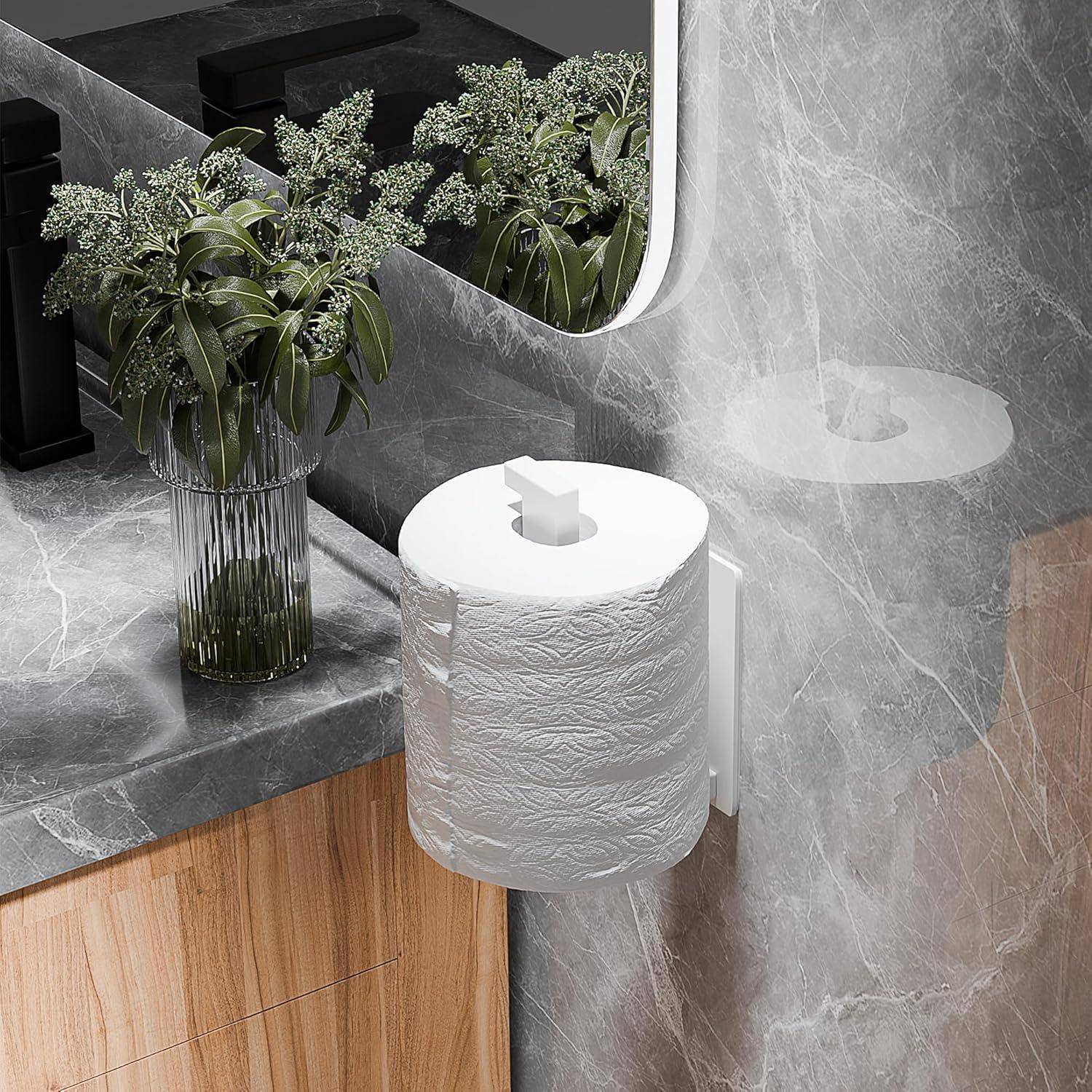 Wandmontierter Toilettenpapierhalter mit einer weißen Rolle neben einer grauen Steinspülenplatte, Blumenvase und Spiegelreflexion in einem modernen Badezimmer.