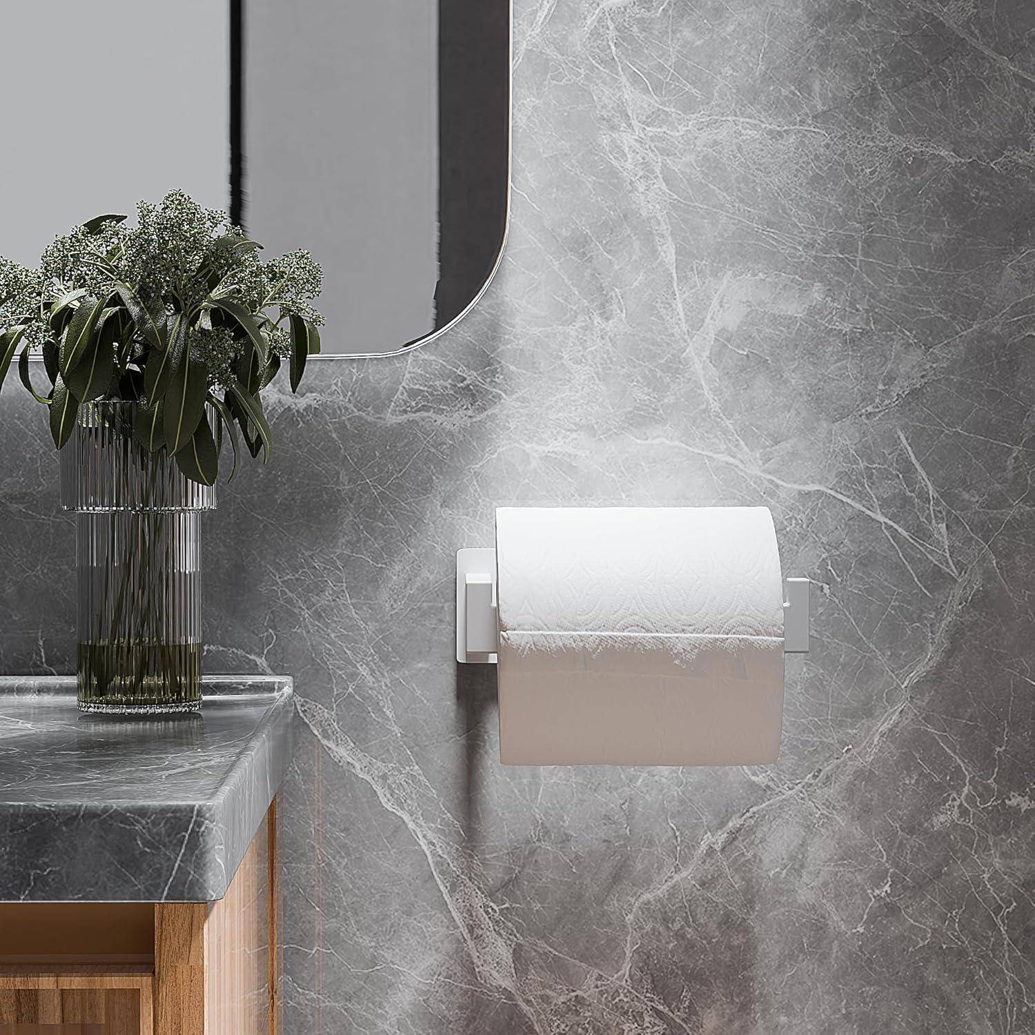 Modernes Badezimmer mit Marmor-Wand, montiertem Toilettenpapierhalter und Vase mit Grünpflanzen auf einer Steinarbeitsplatte.