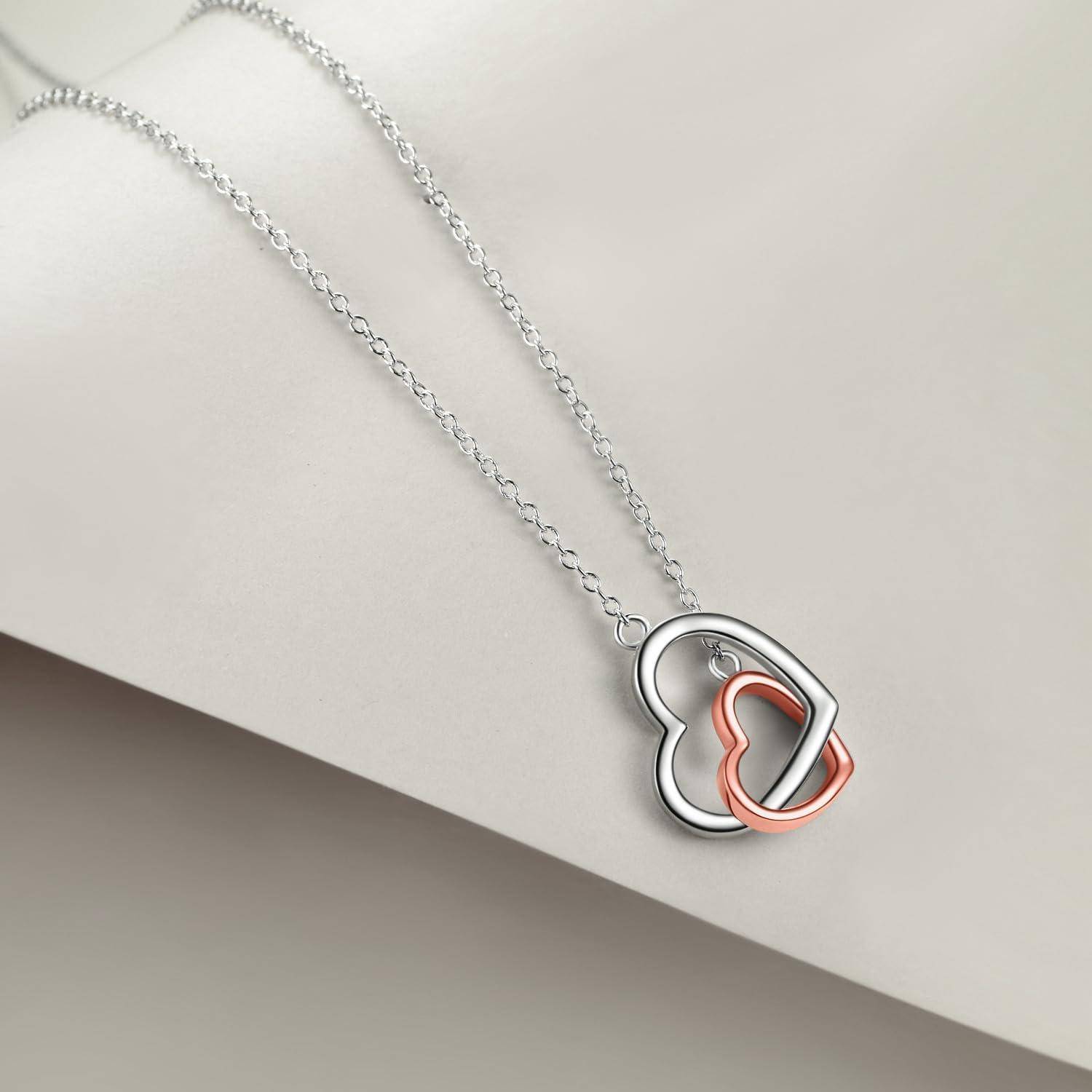 Silberkette mit verschlungenem herzförmigem Anhänger in Silber und Roségold auf hellem Hintergrund.