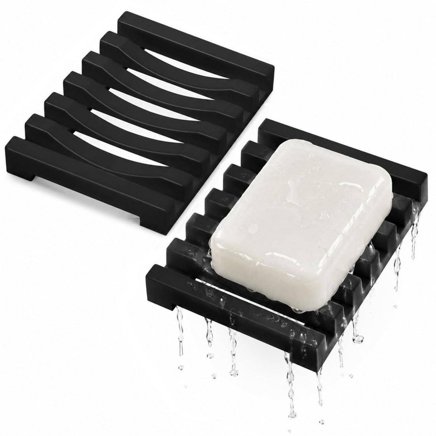 Schwarze Seifenschale mit schlitzförmigem Ablaufgitter und einem weißen Stück Seife, gezeigt mit Wasser, das heruntertropft, um die Drainage zu demonstrieren.