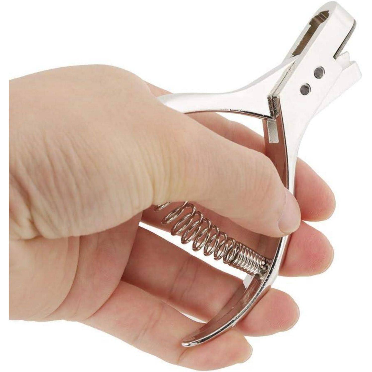 Nahaufnahme einer Hand, die einen federbelasteten Metall-Nagelknipser gegen einen weißen Hintergrund hält.