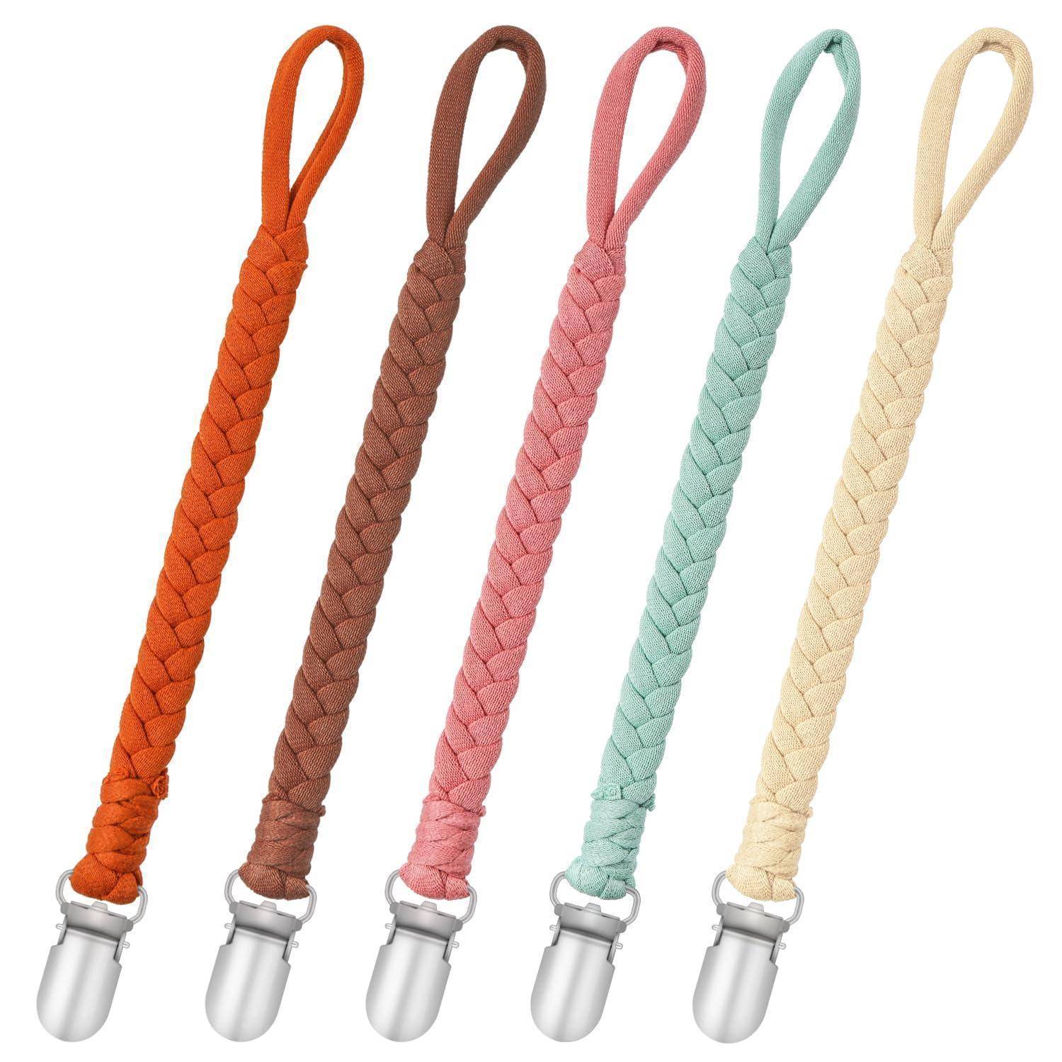 Fünf geflochtene Umhängebänder in Orange, Braun, Rosa, Minze und Creme, jeweils mit einer silbernen Metallschließe unten.